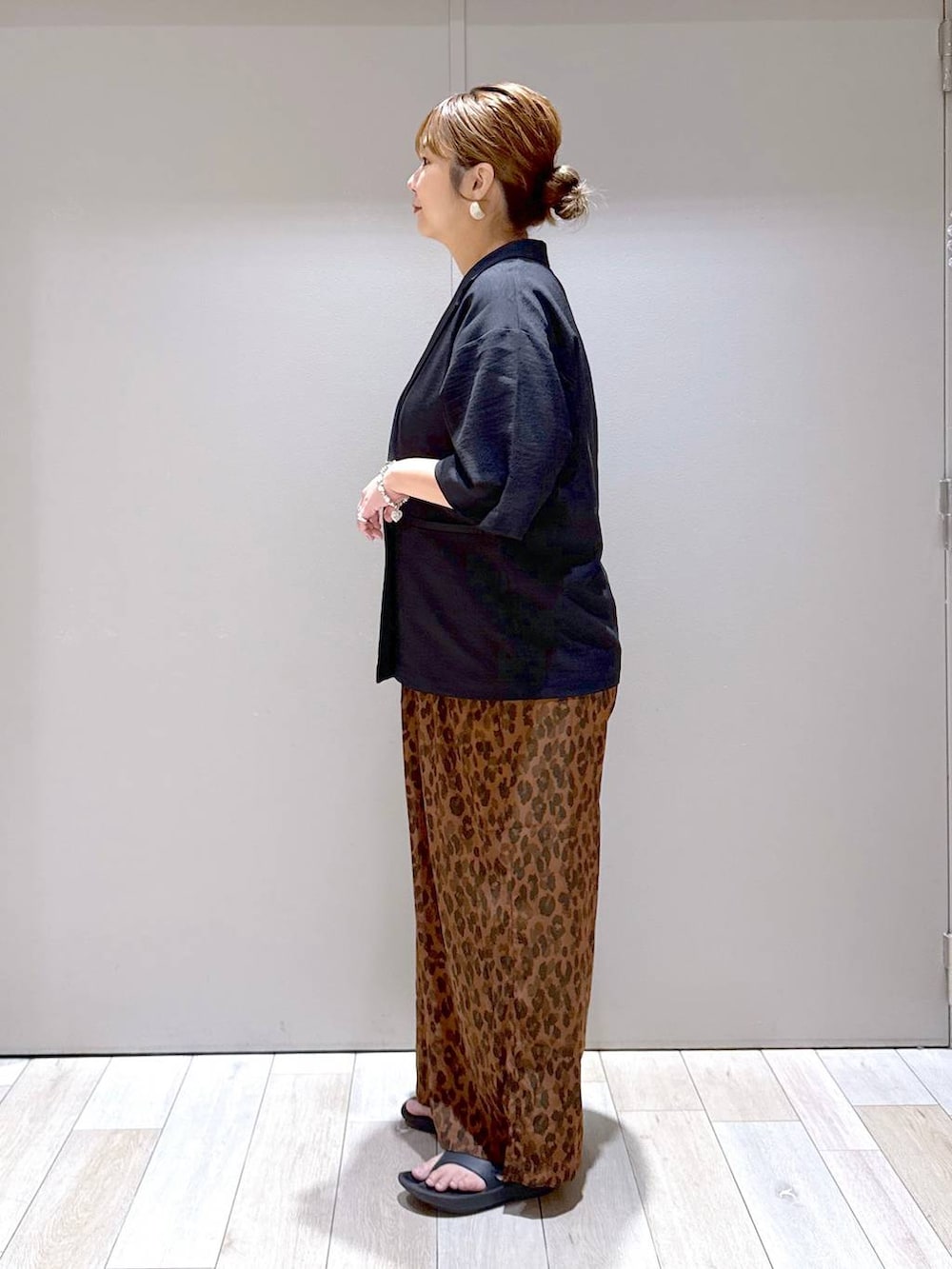 ブラック系のテーラードジャケット、ブラック系のサンダル、ブラック系のハンドバッグを着用したレディースの夏コーディネートの4枚目の写真