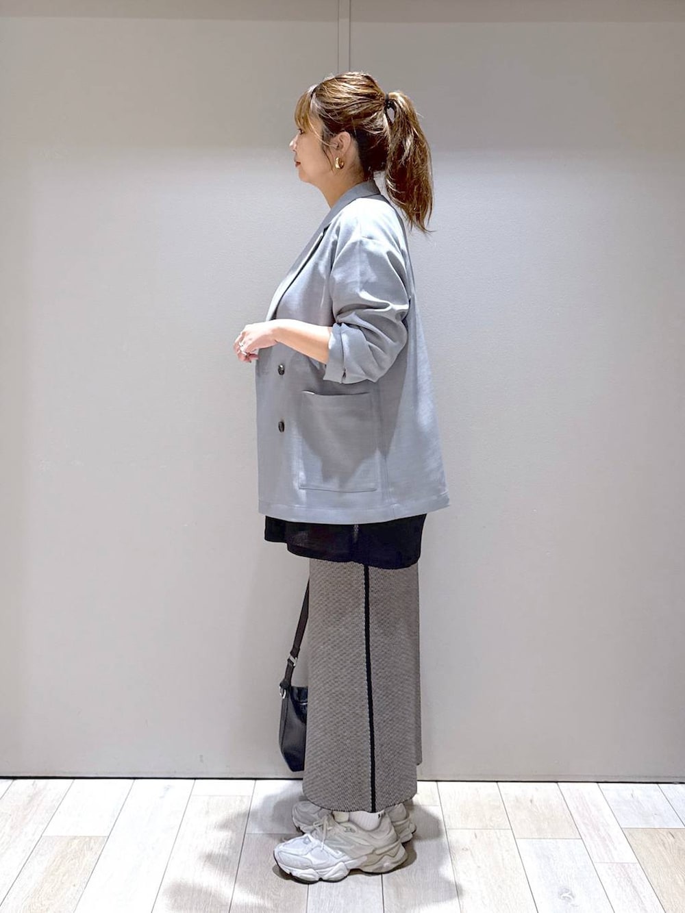 ブラック系のスカート、グレー系のテーラードジャケット、ブラック系のショルダーバッグを着用したレディースの秋コーディネートの4枚目の写真