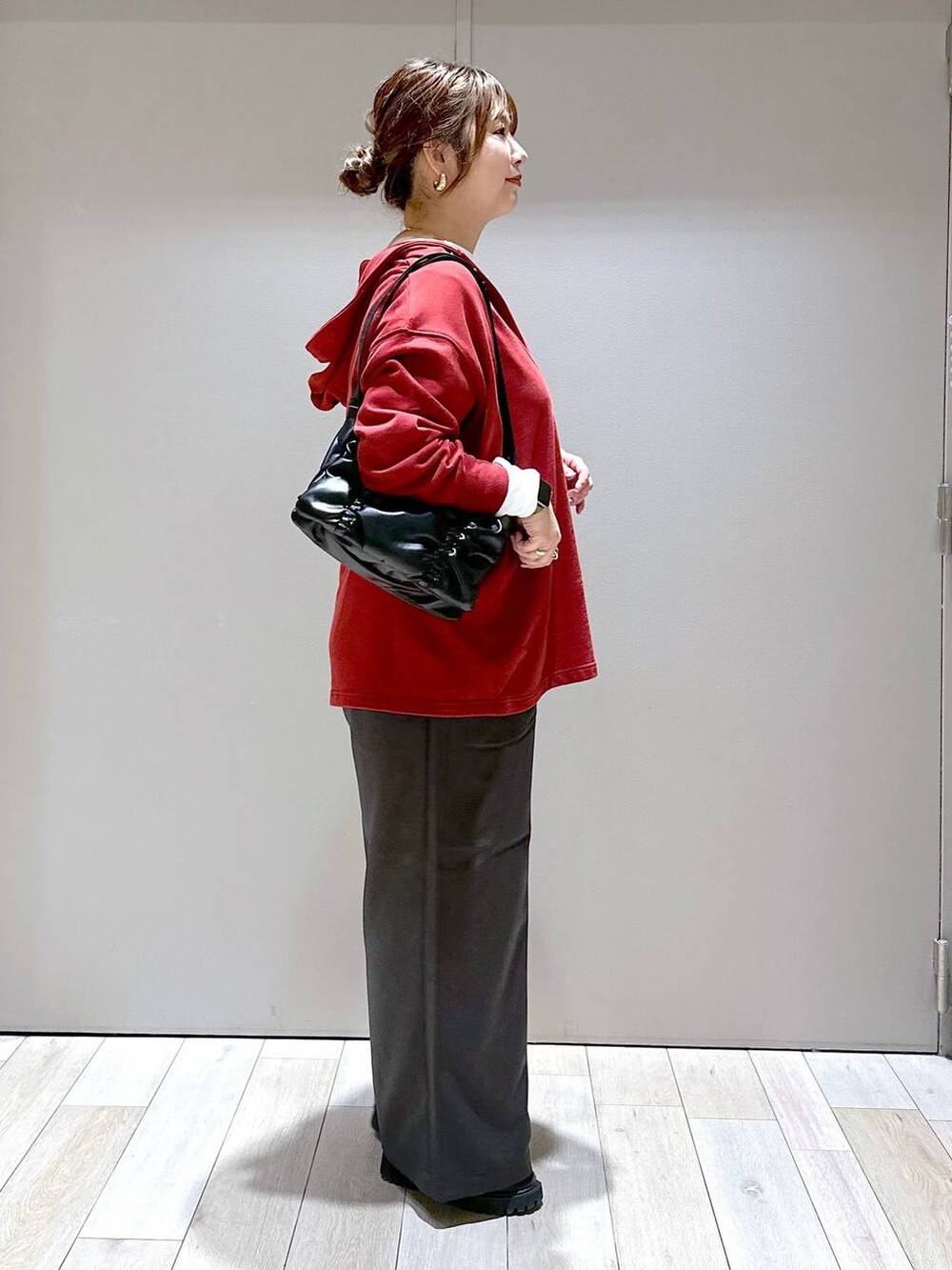 ブラック系のショルダーバッグ、レッド系のチュニック、グレー系のその他パンツを着用したレディースの秋コーディネートの2枚目の写真