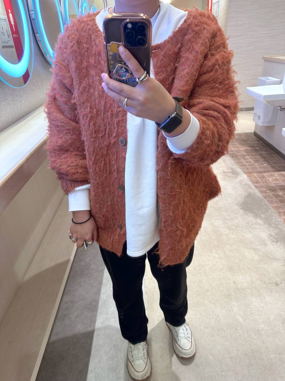 ブラック系のその他パンツ、オレンジ系のカーディガン/ボレロを着用したレディースの冬コーディネートの3枚目の写真