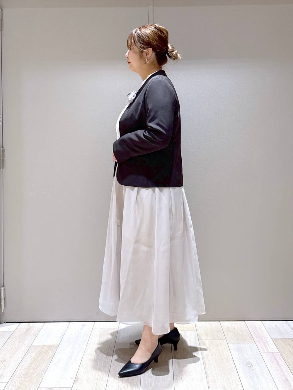 ベージュ系のスカート、ホワイト系のシャツ/ブラウス、ブラック系のスーツジャケットを着用したレディースの冬コーディネートの4枚目の写真