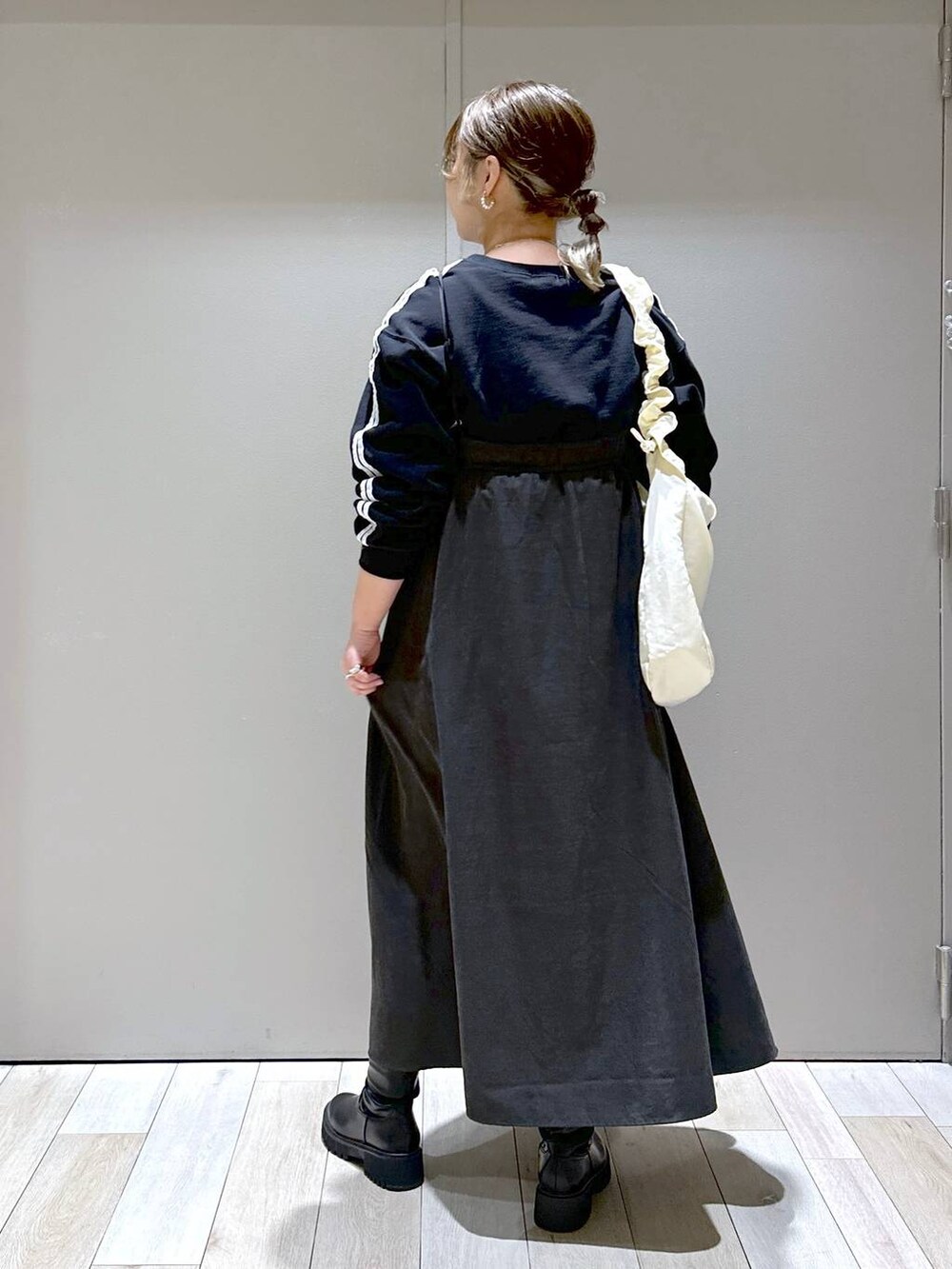 ブラック系のブーツ、ホワイト系のショルダーバッグ、ブラック系のTシャツ/カットソーを着用したレディースの秋コーディネートの3枚目の写真