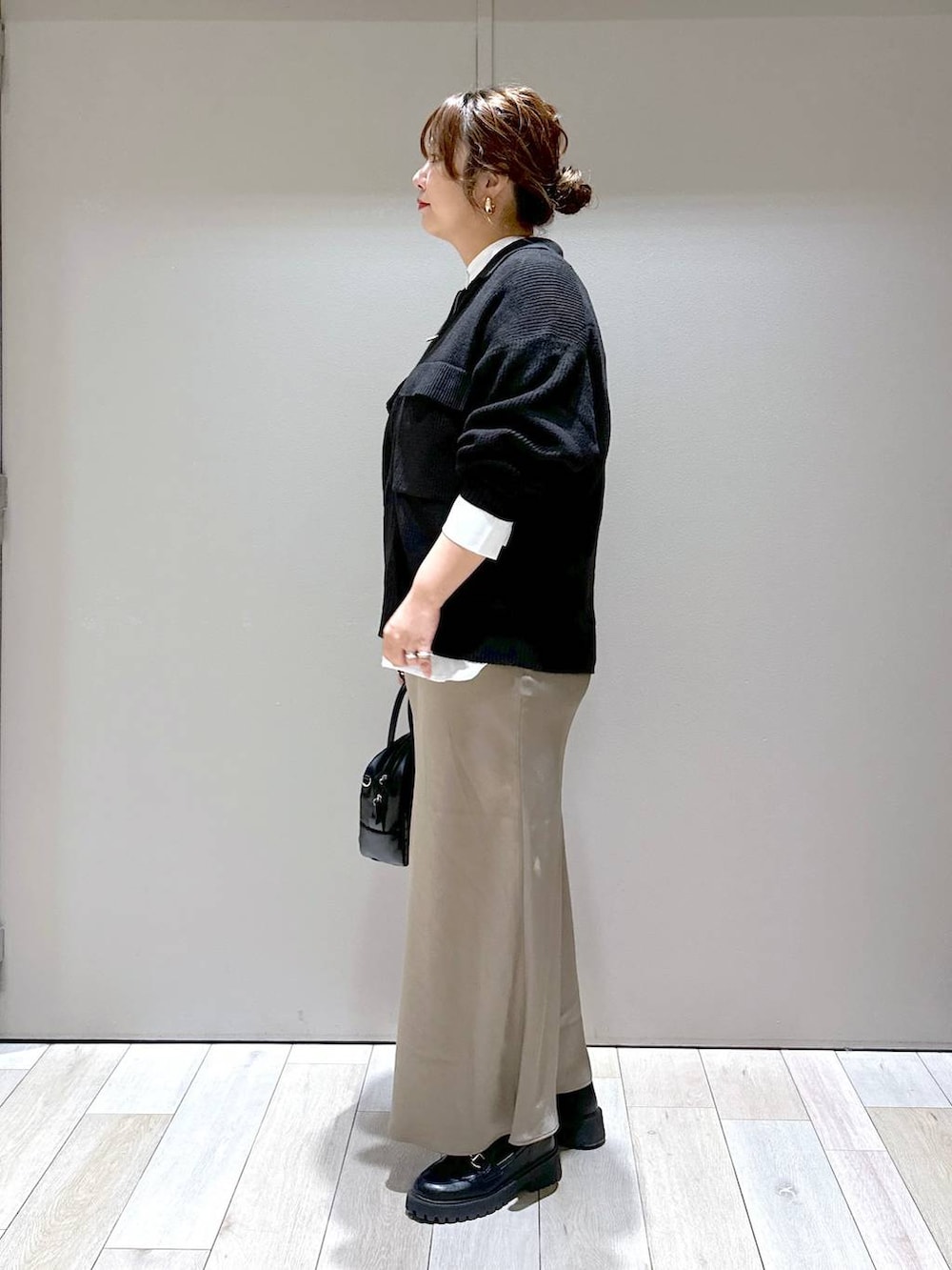 ブラック系のローファー、ブラック系のカーディガン/ボレロ、ブラウン系のスカートを着用したレディースの秋コーディネートの4枚目の写真