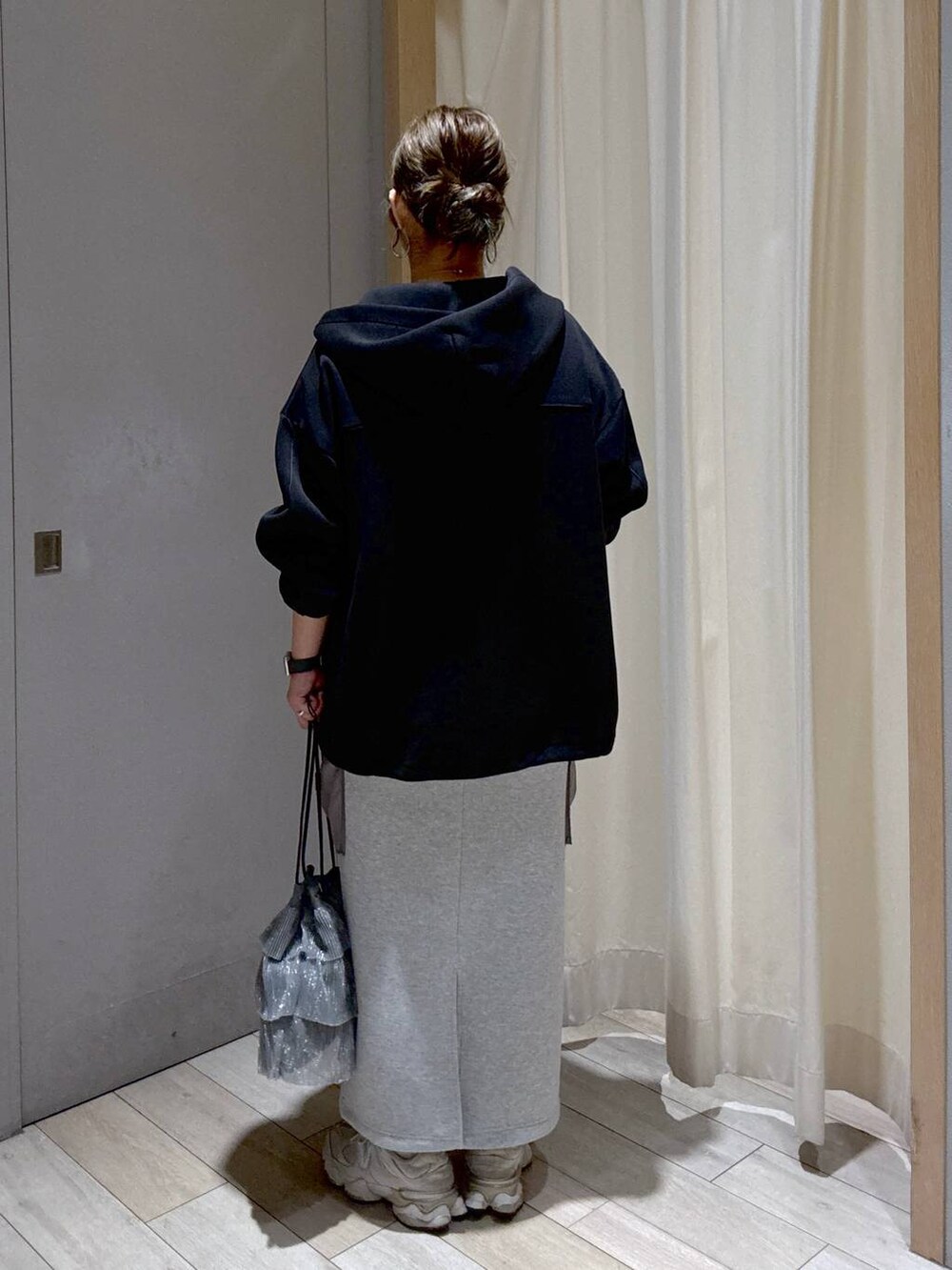 ブラック系のブルゾン、グレー系のスカート、シルバー系のショルダーバッグを着用したレディースの秋コーディネートの3枚目の写真