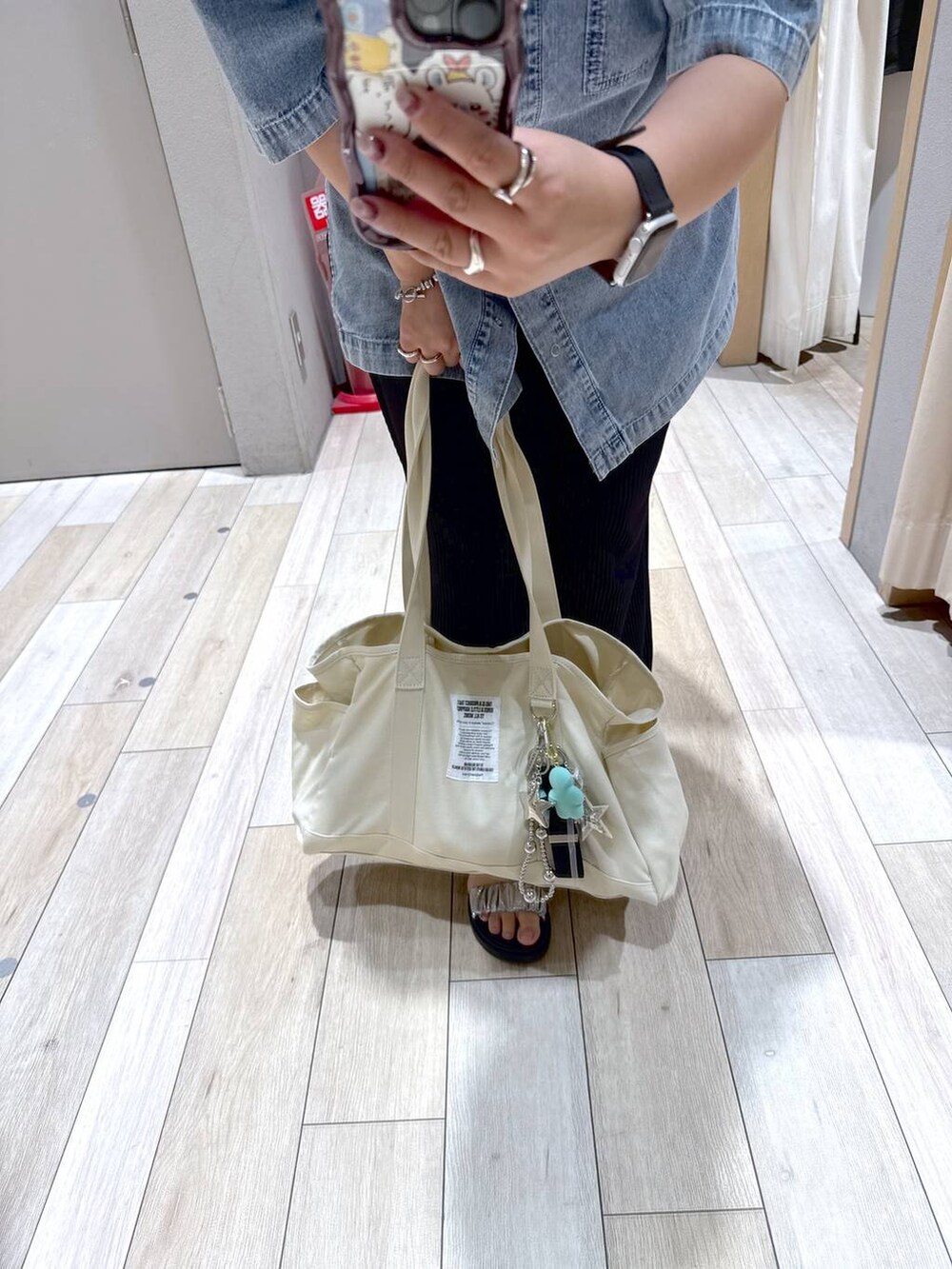 ブルー系のシャツ/ブラウス、シルバー系のキーホルダー、ブラック系のスマホグッズを着用したレディースの夏コーディネートの2枚目の写真