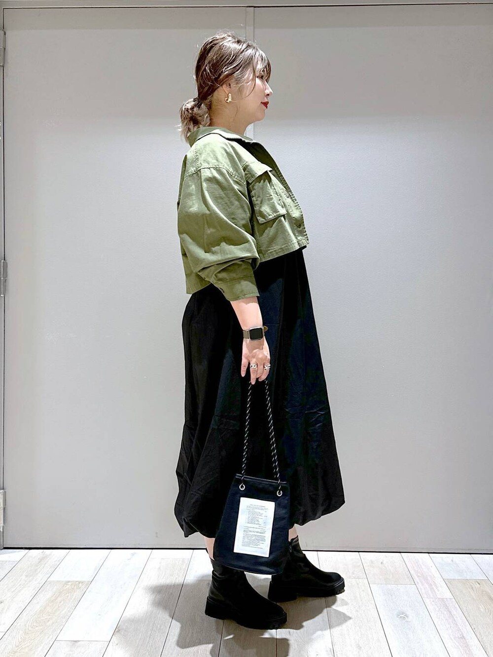 ホワイト系のTシャツ/カットソー、グリーン系のミリタリージャケット、ブラック系のブーツを着用したレディースの秋コーディネートの2枚目の写真