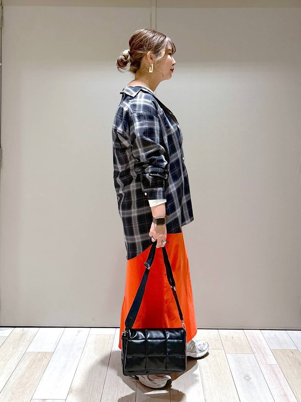 ブラック系のショルダーバッグ、ブラック系のシャツ/ブラウス、レッド系のスカートを着用したレディースの春コーディネートの2枚目の写真