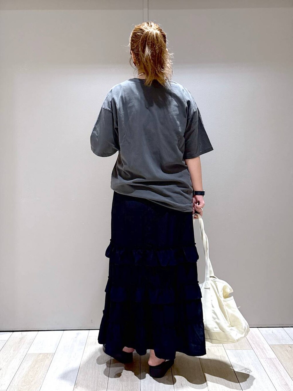 ホワイト系のサンダル、ブラック系のスカート、グレー系のTシャツ/カットソーを着用したレディースの夏コーディネートの3枚目の写真