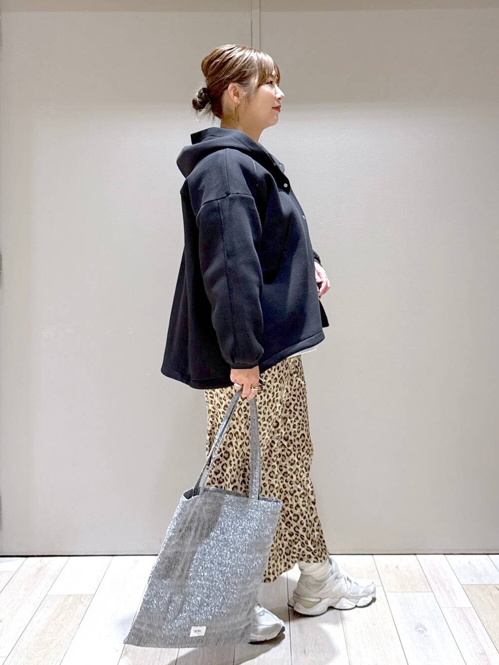 シルバー系のトートバッグ、ブラック系のブルゾン、その他のスカートを着用したレディースの冬コーディネートの2枚目の写真