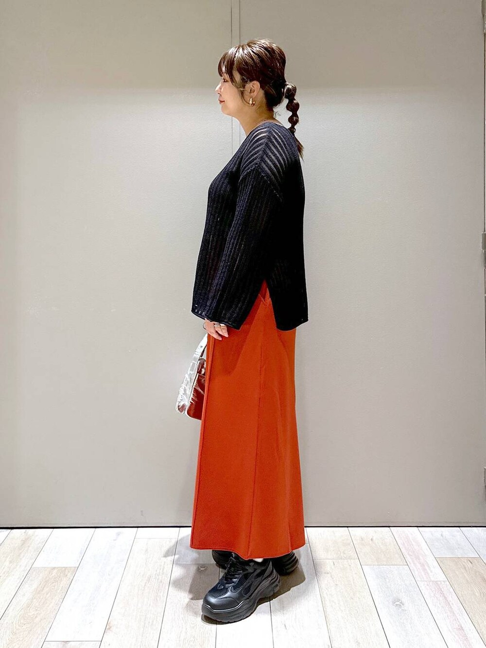 シルバー系のショルダーバッグ、ブラック系のニット/セーター、グレー系のタンクトップを着用したレディースの夏コーディネートの4枚目の写真