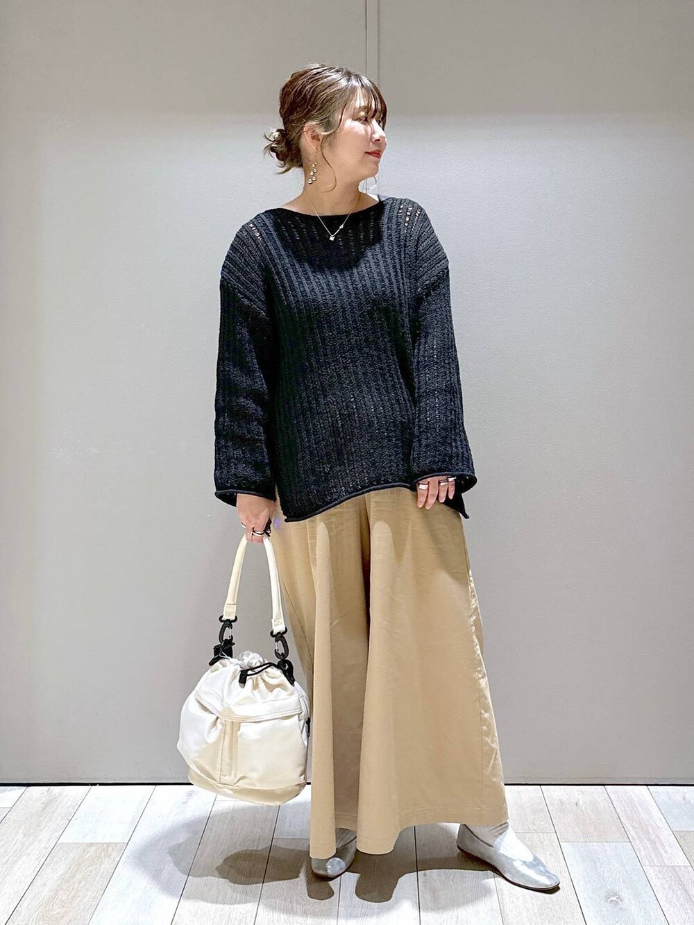 グレー系のパンプス、ホワイト系のショルダーバッグ、ベージュ系のチノパンツを着用したレディースの春コーディネートの4枚目の写真