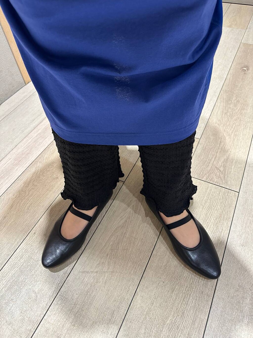 ブラック系のショルダーバッグ、ブルー系のワンピース、ブラック系のパンプスを着用したレディースの春コーディネートの5枚目の写真