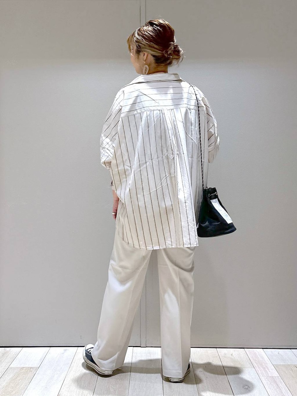 ブラック系のタンクトップ、ベージュ系のスラックス、ベージュ系のシャツ/ブラウスを着用したレディースの夏コーディネートの3枚目の写真