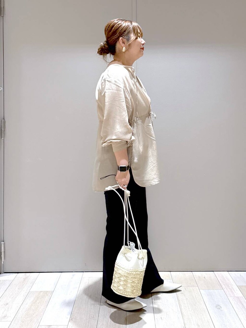 ブラック系のスラックス、ホワイト系のパンプス、ブラウン系のシャツ/ブラウスを着用したレディースの春コーディネートの2枚目の写真