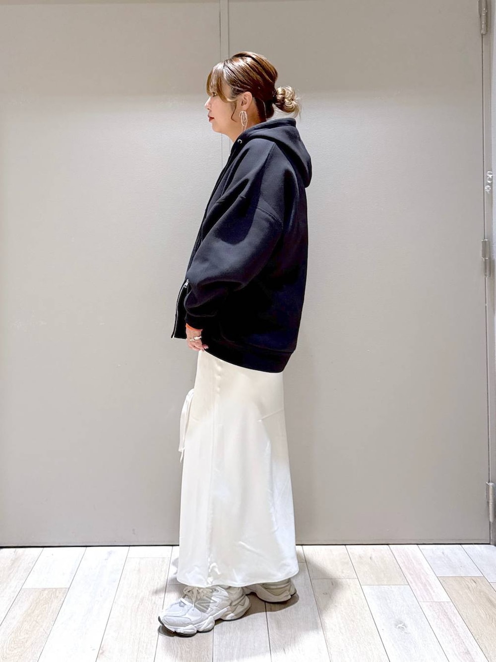 ホワイト系のスカート、ブラック系のパーカー、オレンジ系のTシャツ/カットソーを着用したレディースの冬コーディネートの4枚目の写真