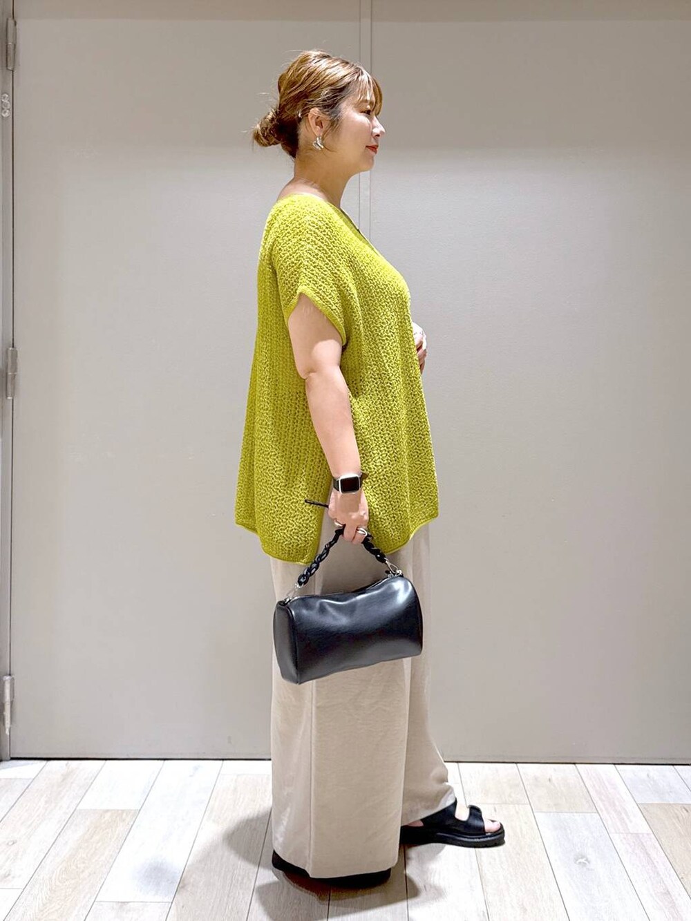 ブラック系のサンダル、ベージュ系のその他パンツ、ブラック系のショルダーバッグを着用したレディースの春コーディネートの2枚目の写真