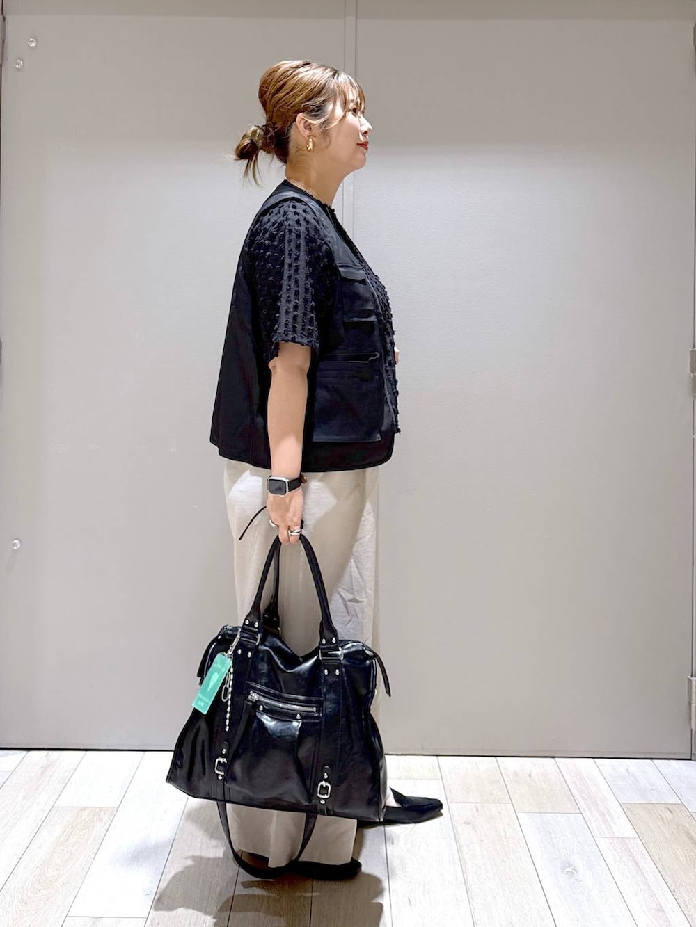 ブラック系のトートバッグ、ベージュ系のその他パンツ、ブラック系のローファーを着用したレディースの春コーディネートの2枚目の写真