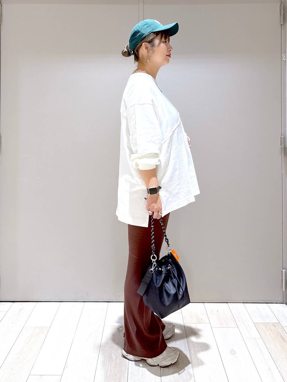 ブラック系のショルダーバッグ、ホワイト系のTシャツ/カットソー、ブラウン系のマタニティウェア/グッズを着用したレディースの秋コーディネートの2枚目の写真