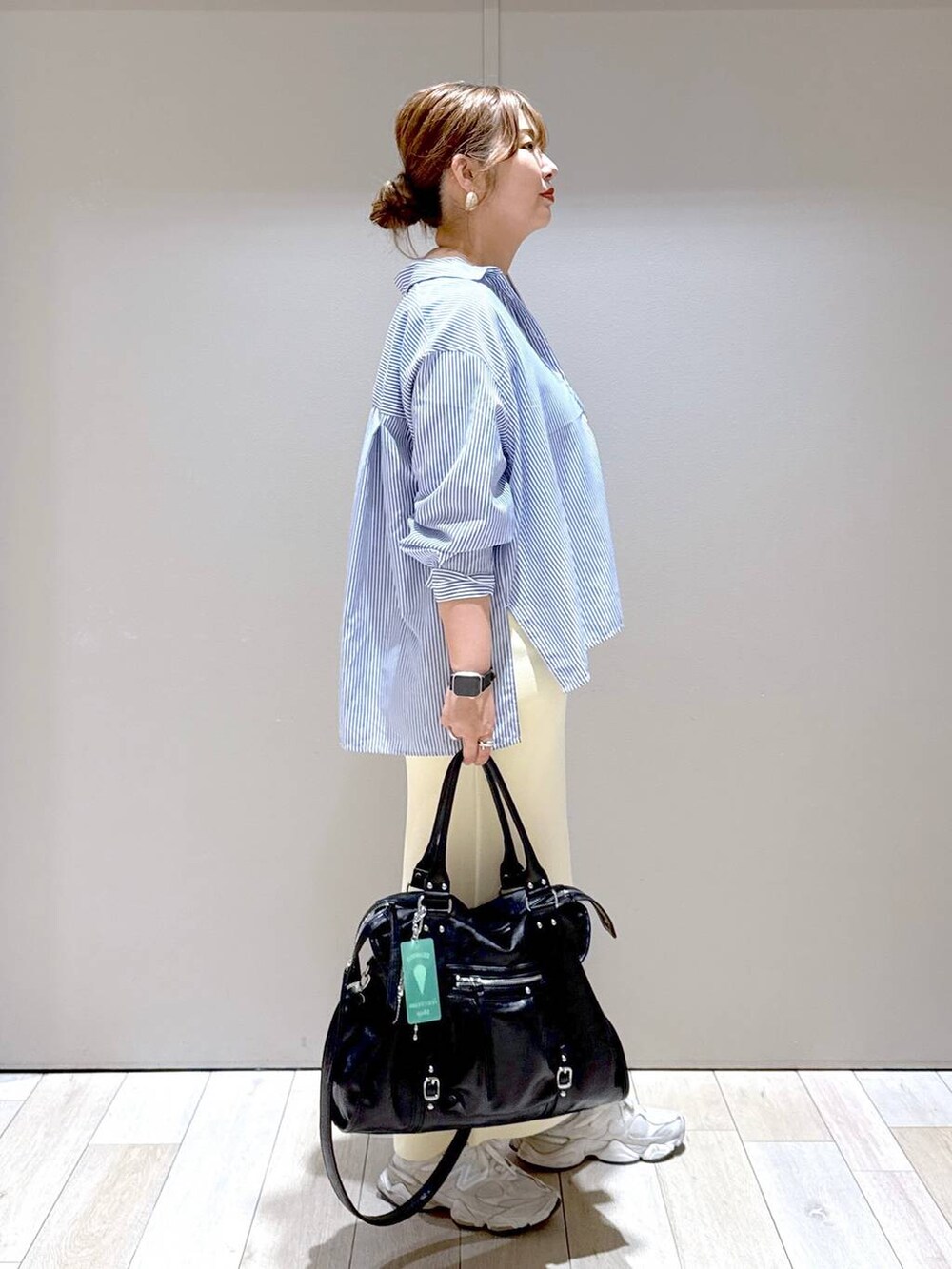 ホワイト系のスカート、ブラック系のトートバッグ、ブルー系のシャツ/ブラウスを着用したレディースの春コーディネートの2枚目の写真