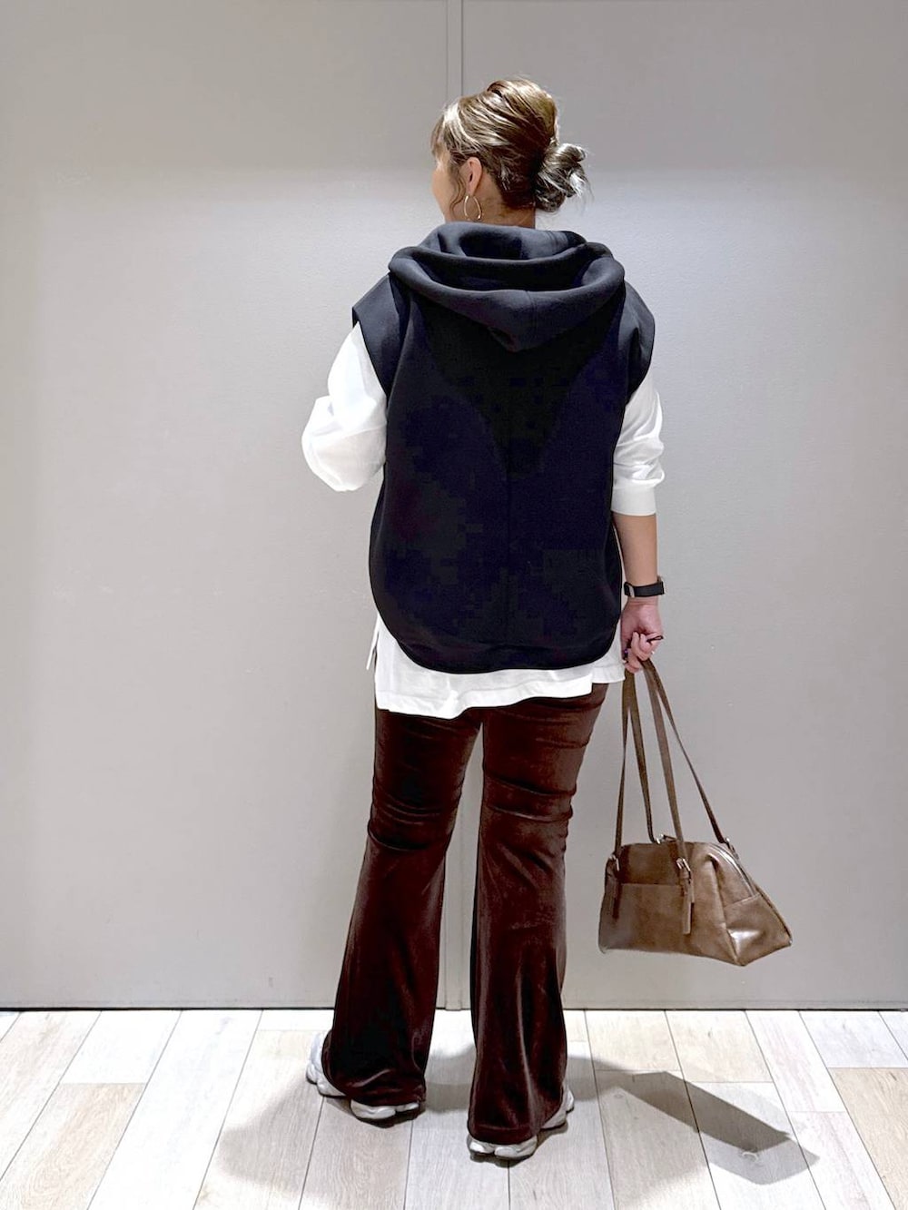 ブラウン系のその他パンツ、ブラウン系のボストンバッグ、ブラック系のベストを着用したレディースの秋コーディネートの3枚目の写真