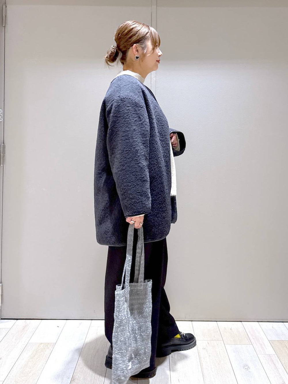 シルバー系のトートバッグ、グレー系のその他アウター、ブラック系のその他パンツを着用したレディースの冬コーディネートの2枚目の写真
