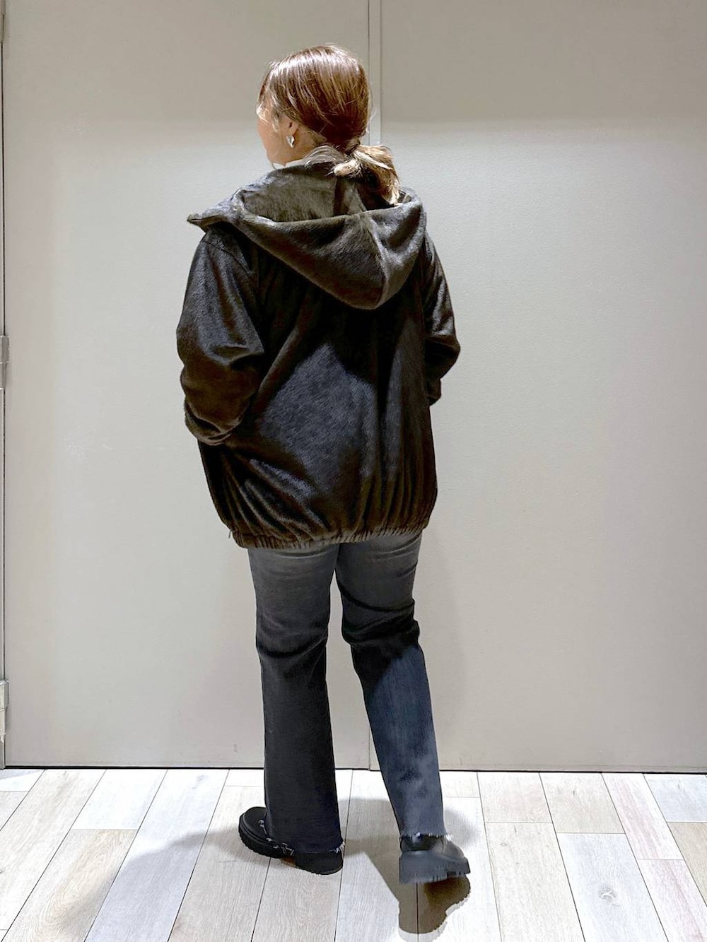 ホワイト系のTシャツ/カットソー、グリーン系のブルゾン、ブラック系のブーツを着用したレディースの冬コーディネートの3枚目の写真