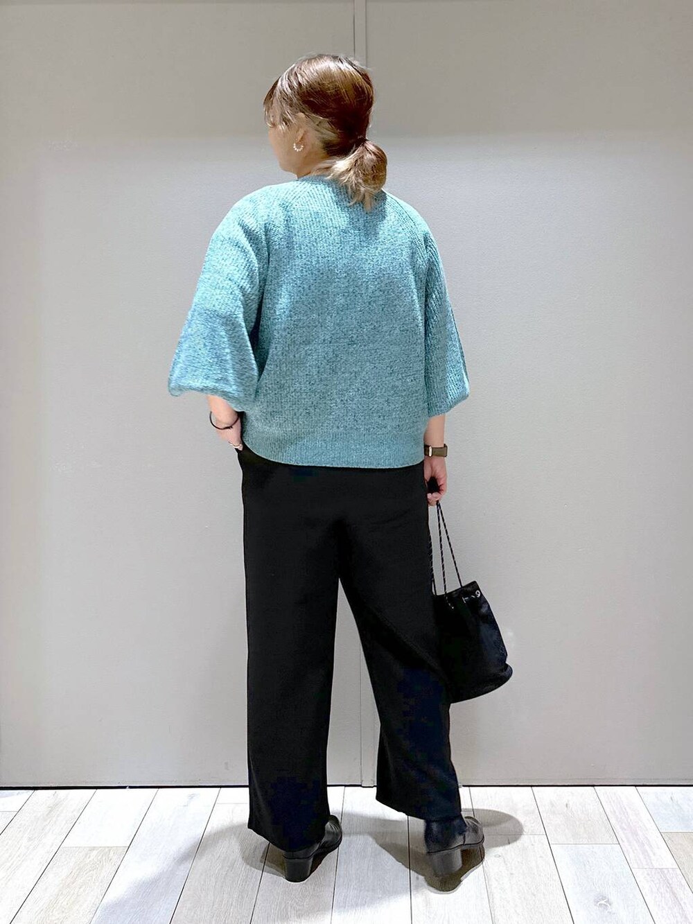 ブラック系のブーツ、ブラック系のその他パンツ、グリーン系のニット/セーターを着用したレディースの秋コーディネートの3枚目の写真