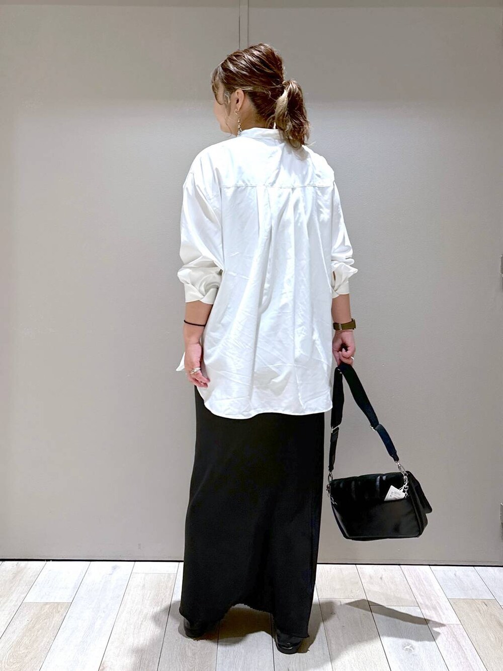 ブラック系のショルダーバッグ、ブラック系のパンプス、ブラック系のスカートを着用したレディースの春コーディネートの3枚目の写真