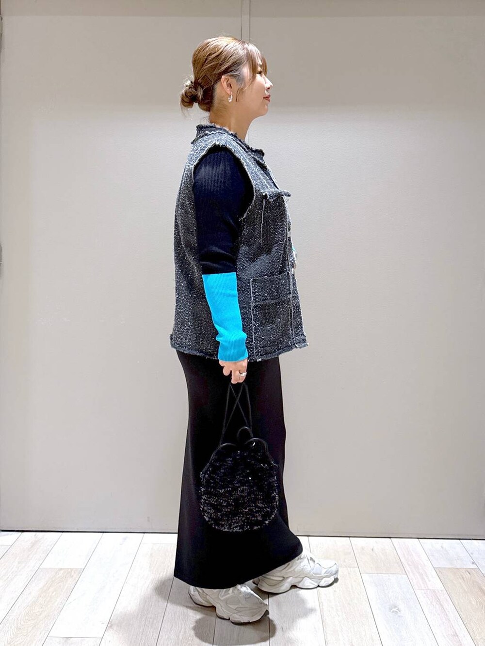 ブラック系のショルダーバッグ、ブラック系のスカート、ブラック系のニット/セーターを着用したレディースの冬コーディネートの2枚目の写真