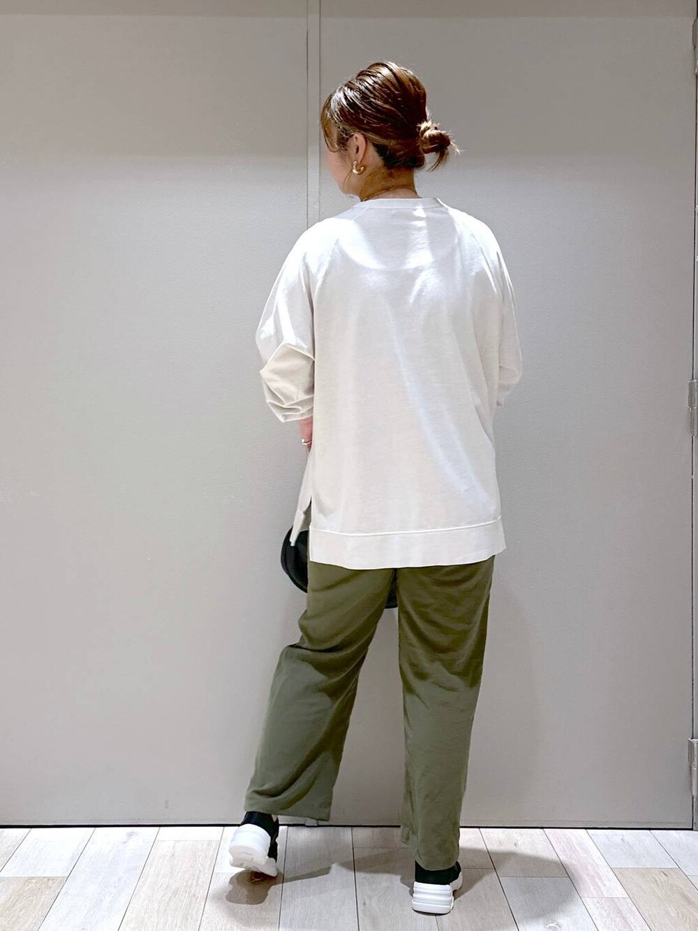 グリーン系のその他パンツ、ホワイト系のTシャツ/カットソー、ブラック系のスニーカーを着用したレディースの夏コーディネートの3枚目の写真