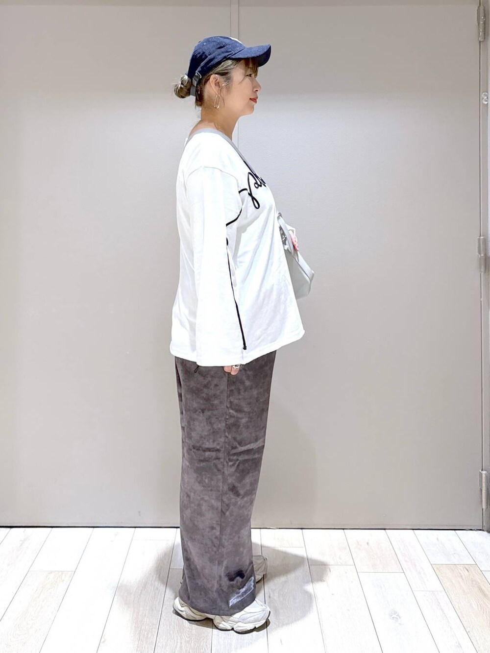 グレー系のショルダーバッグ、グレー系のその他パンツ、ホワイト系のTシャツ/カットソーを着用したレディースの秋コーディネートの2枚目の写真