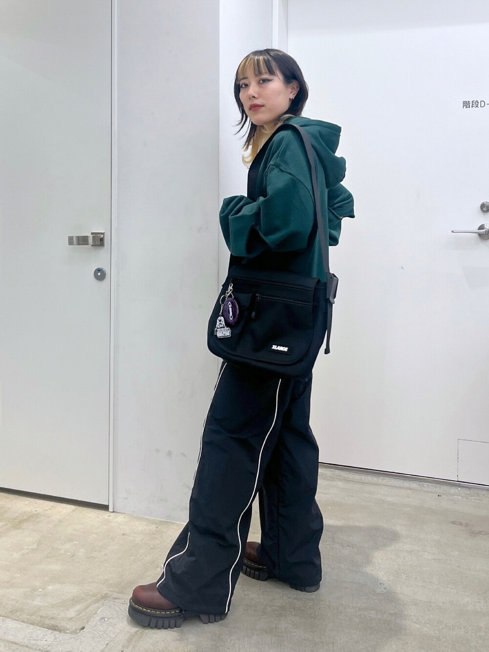 グリーン系のパーカーを着用したレディースの夏コーディネートの2枚目の写真