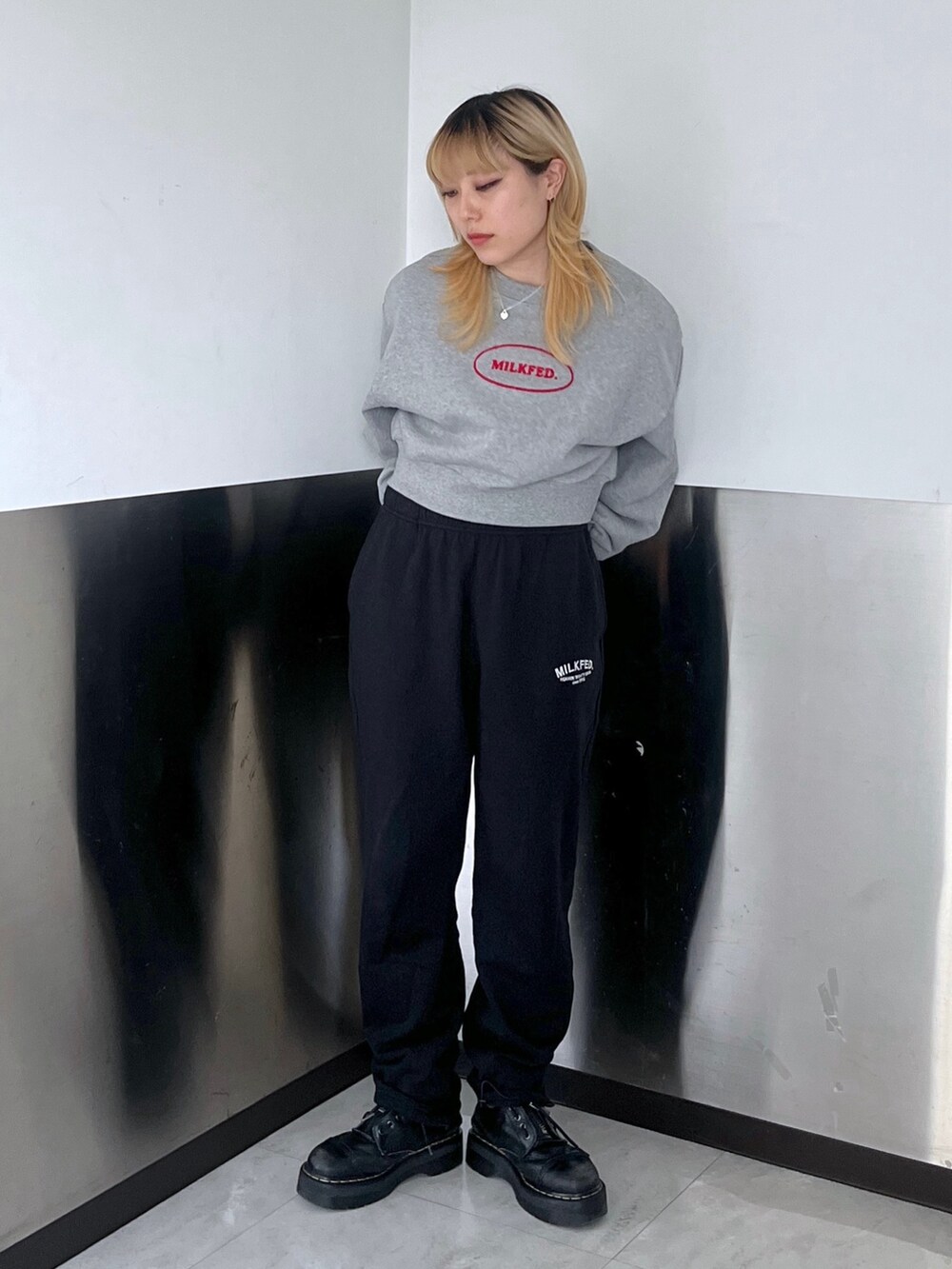 グレー系のスウェット、ブラック系のスウェットパンツ、ブルー系のショルダーバッグを着用したレディースの冬コーディネートの2枚目の写真