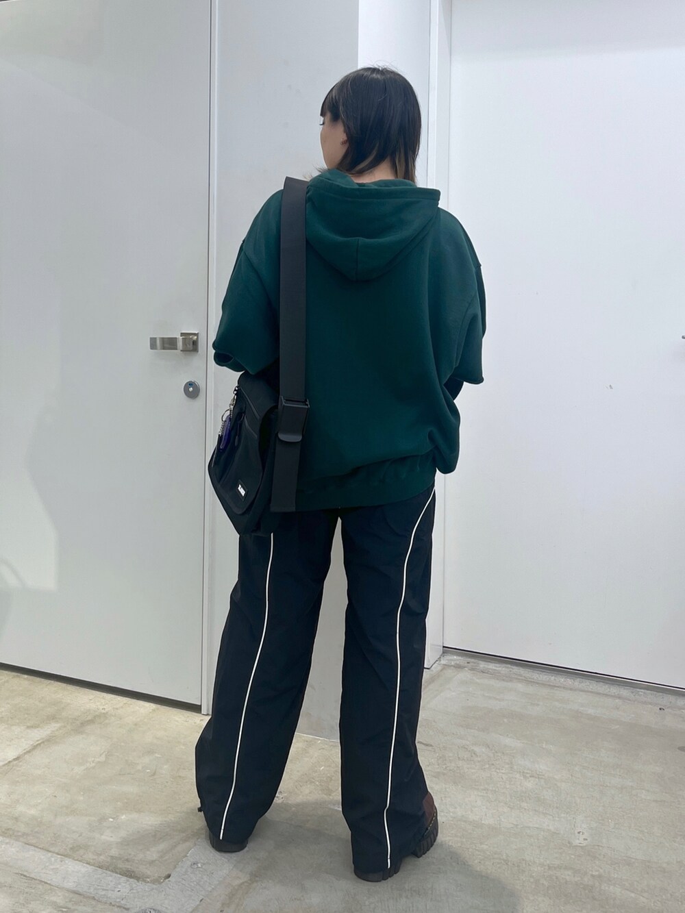 グリーン系のパーカーを着用したレディースの夏コーディネートの3枚目の写真