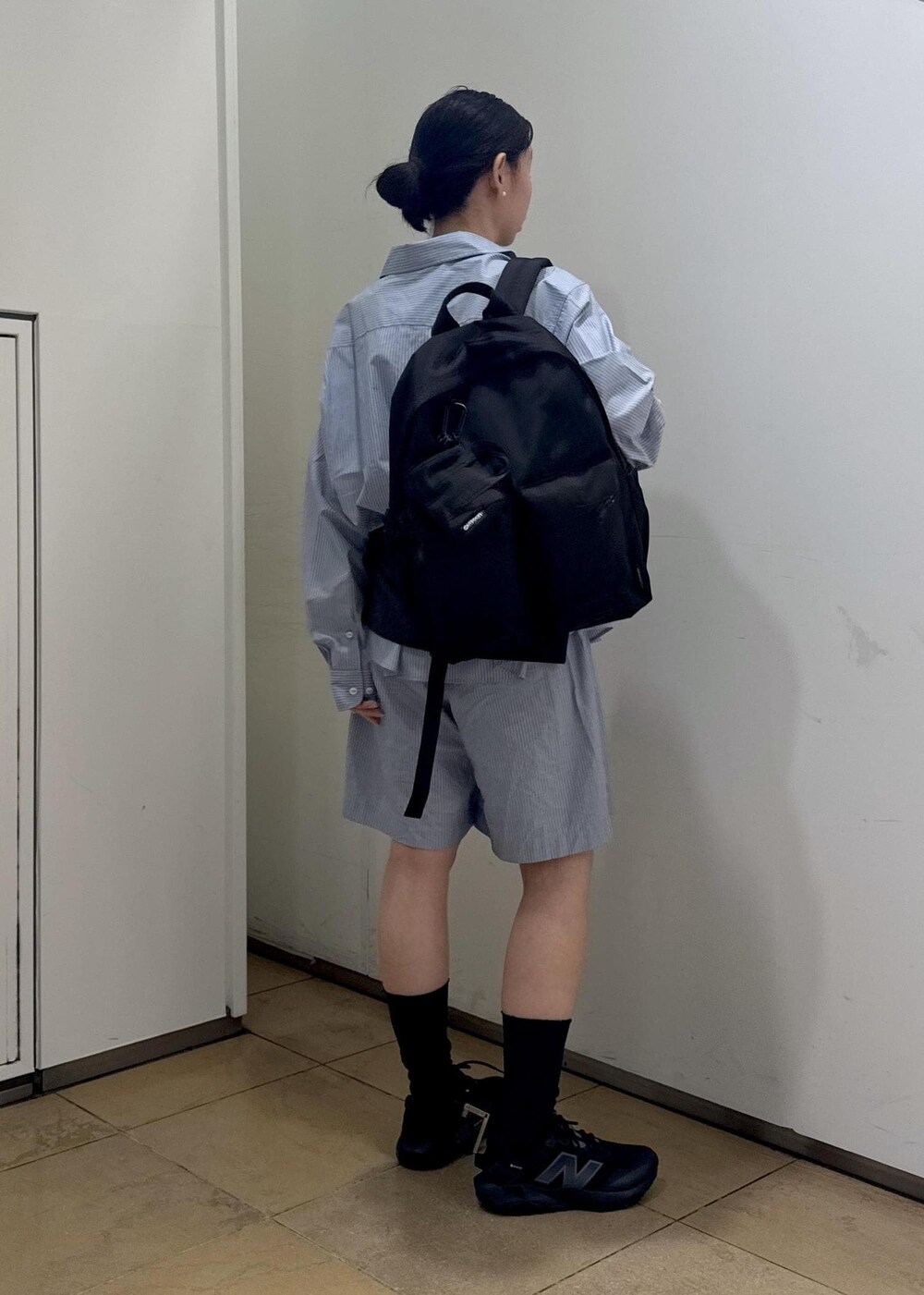 ブラック系のバックパック/リュック、ブラック系のスニーカーを着用したレディースの夏コーディネートの3枚目の写真