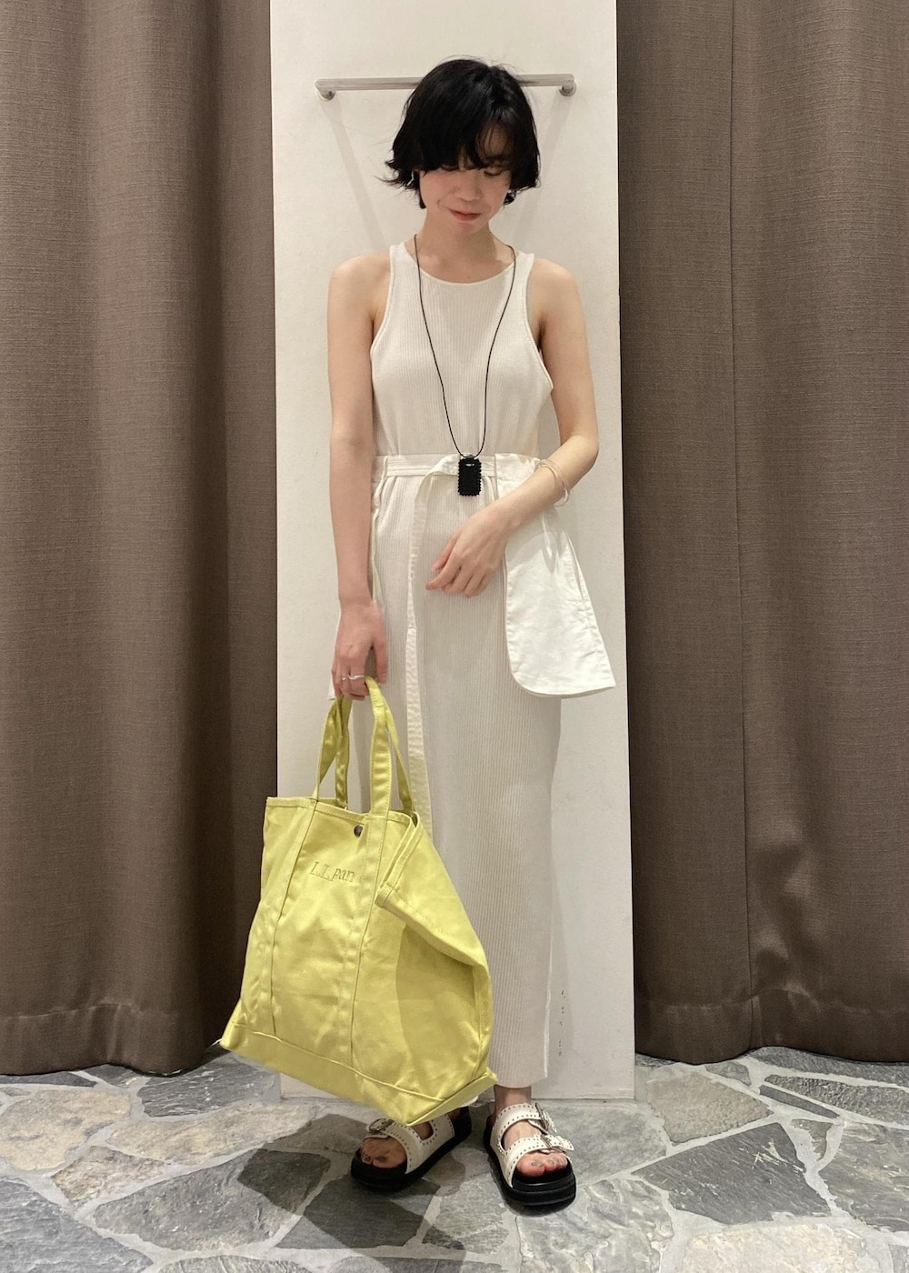 ホワイト系のワンピース、イエロー系のトートバッグ、ホワイト系のベルトを着用したレディースの春コーディネートの4枚目の写真