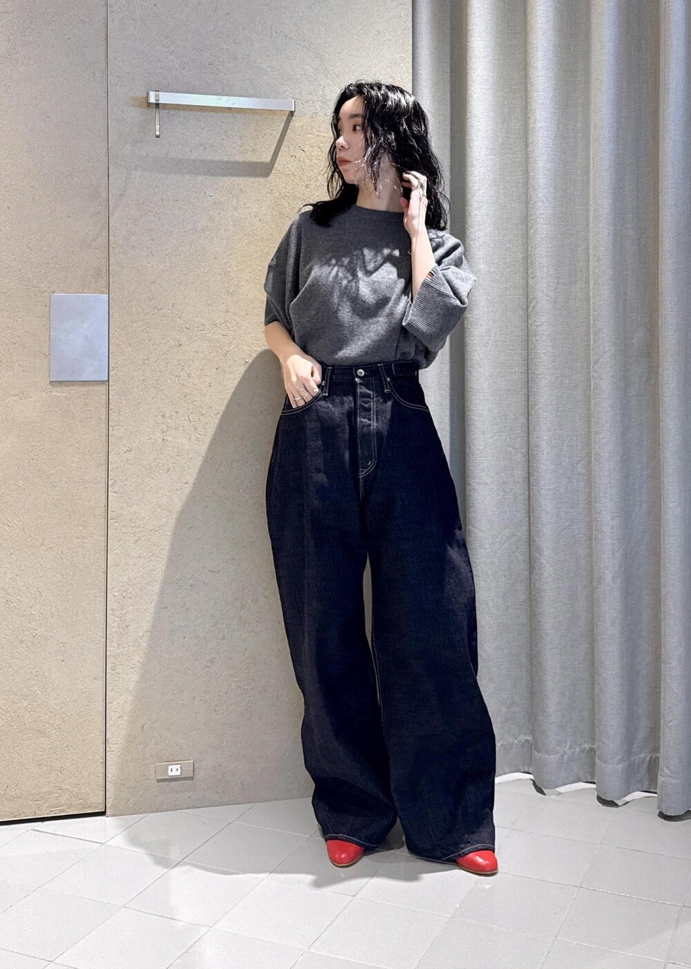 ベージュ系のダウンジャケット/コート、レッド系のパンプス、ブルー系のデニムパンツを着用したレディースの秋コーディネートの3枚目の写真