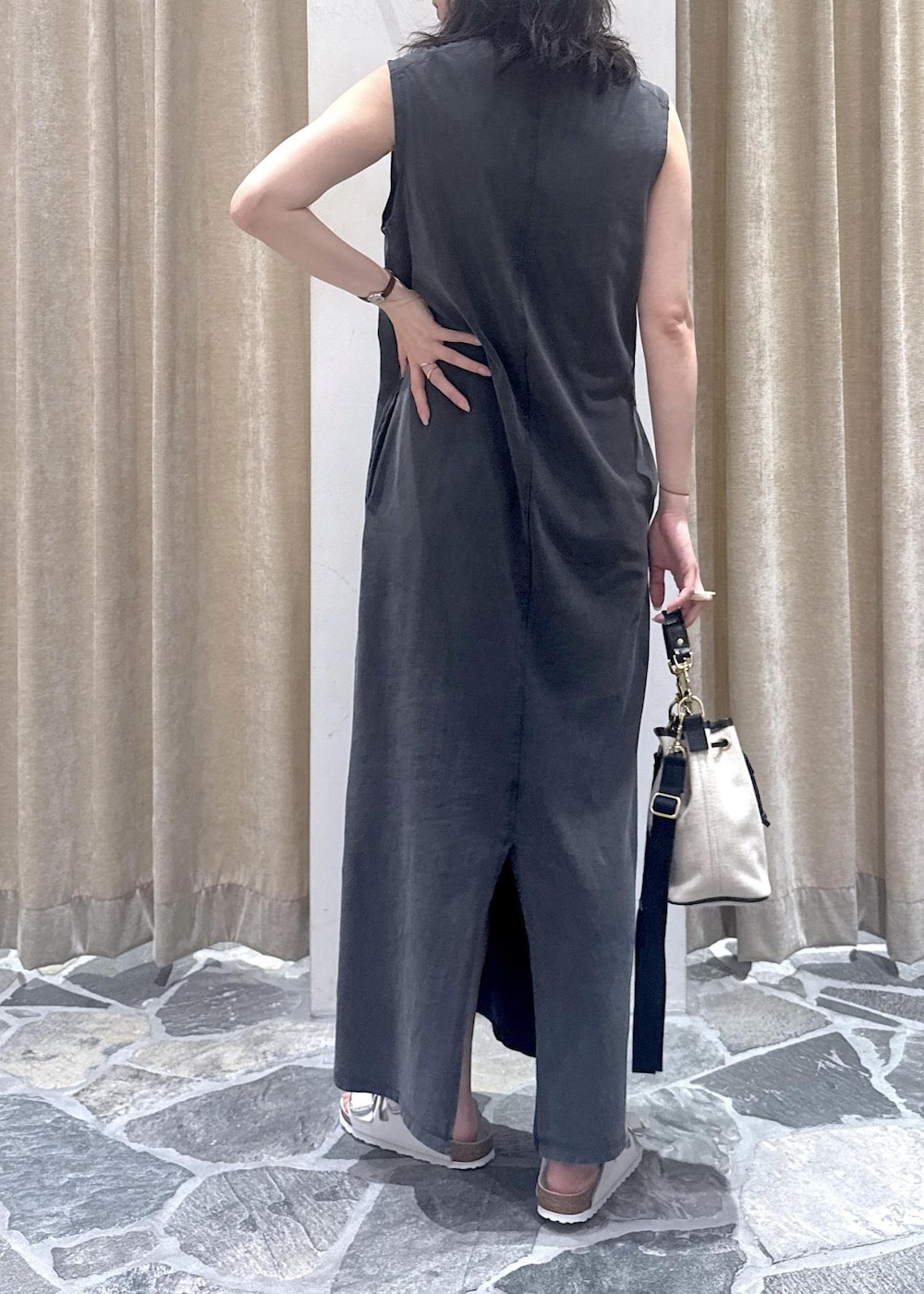 グレー系のワンピース、ホワイト系のサンダル、ホワイト系のショルダーバッグを着用したレディースの夏コーディネートの5枚目の写真