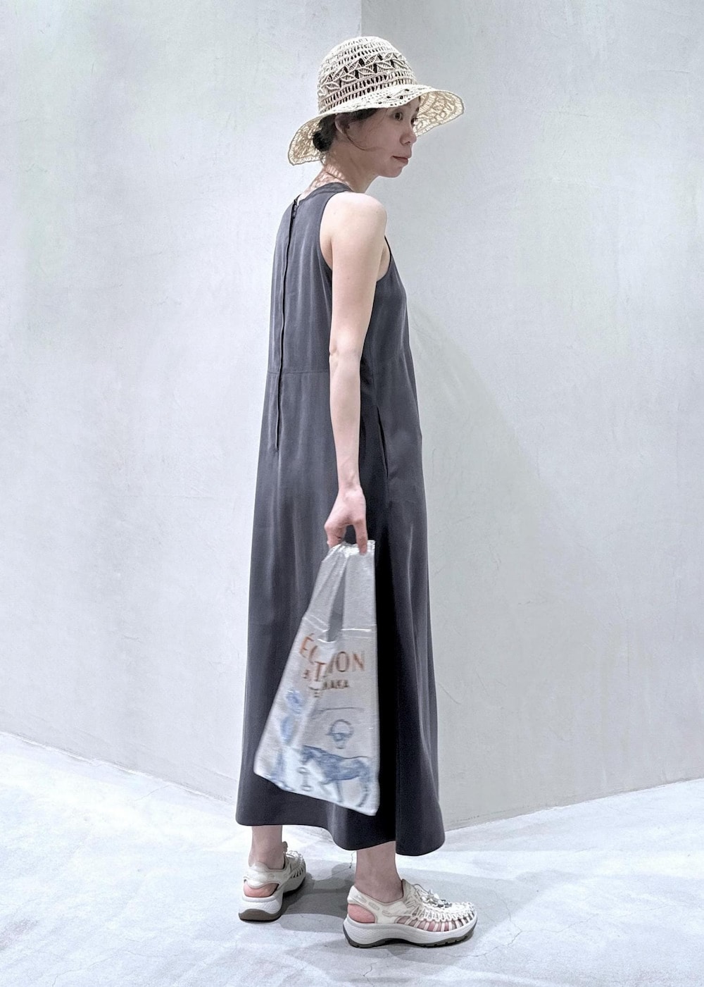 ホワイト系のサンダル、グレー系のワンピース、ホワイト系のハットを着用したレディースの春コーディネートの4枚目の写真