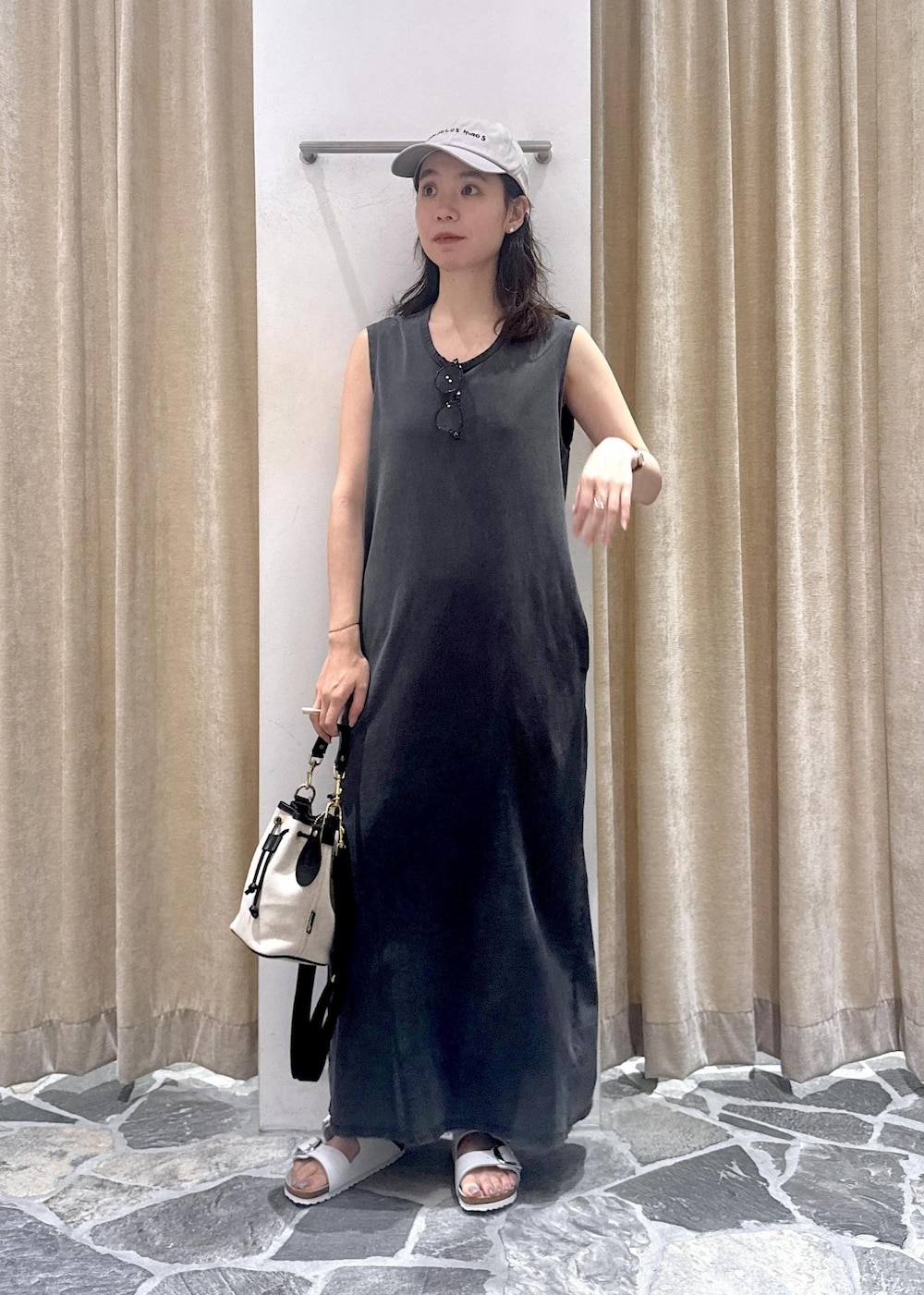 グレー系のワンピース、ホワイト系のサンダル、ホワイト系のショルダーバッグを着用したレディースの夏コーディネートの2枚目の写真