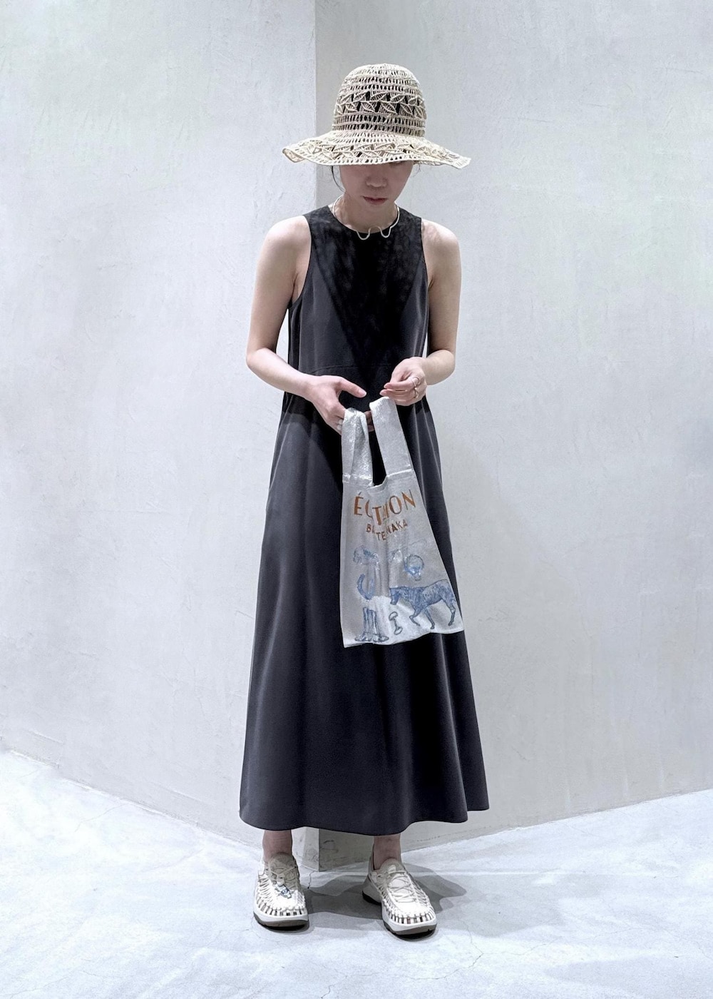 ホワイト系のサンダル、グレー系のワンピース、ホワイト系のハットを着用したレディースの春コーディネートの2枚目の写真