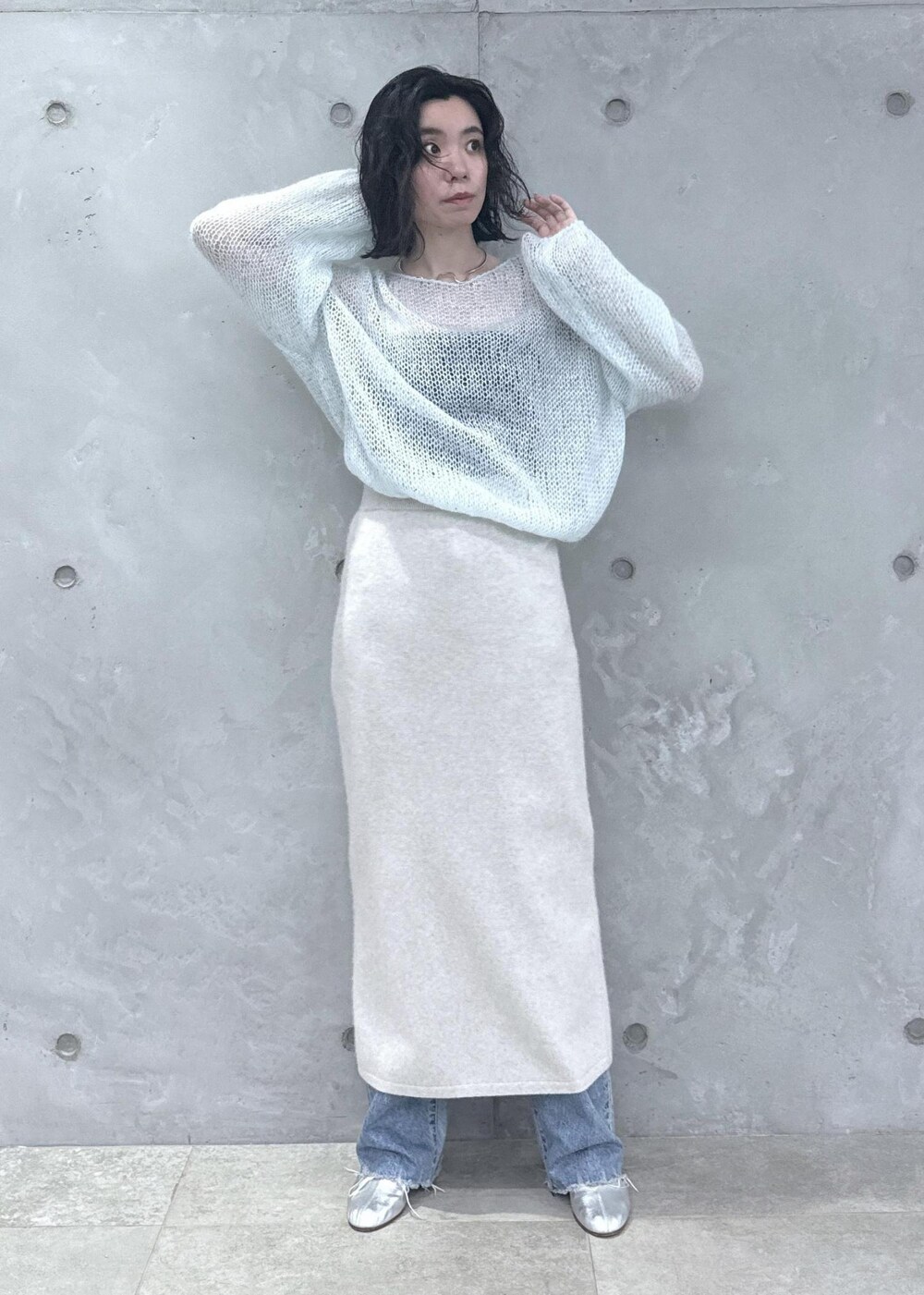 ホワイト系のスカート、ブルー系のニット/セーター、ブルー系のデニムパンツを着用したレディースの秋コーディネートの6枚目の写真