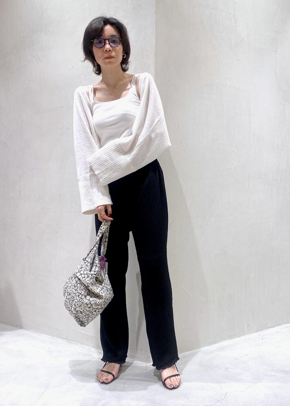 ホワイト系のカーディガン/ボレロ、ブラック系のトートバッグ、ブラック系のその他パンツを着用したレディースの夏コーディネートの3枚目の写真