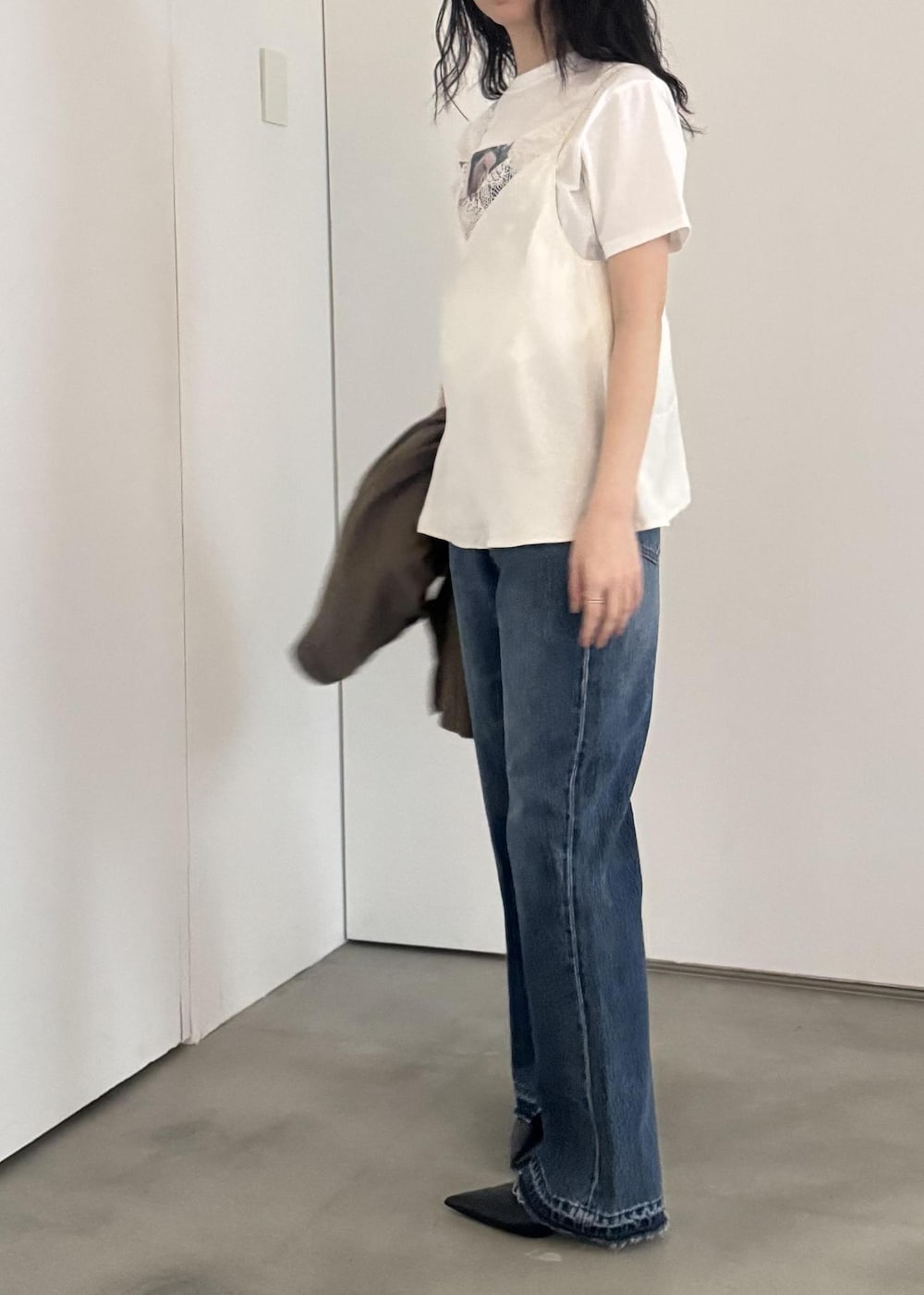 ブルー系のデニムパンツ、ホワイト系のキャミソール、ホワイト系のTシャツ/カットソーを着用したレディースの冬コーディネートの3枚目の写真