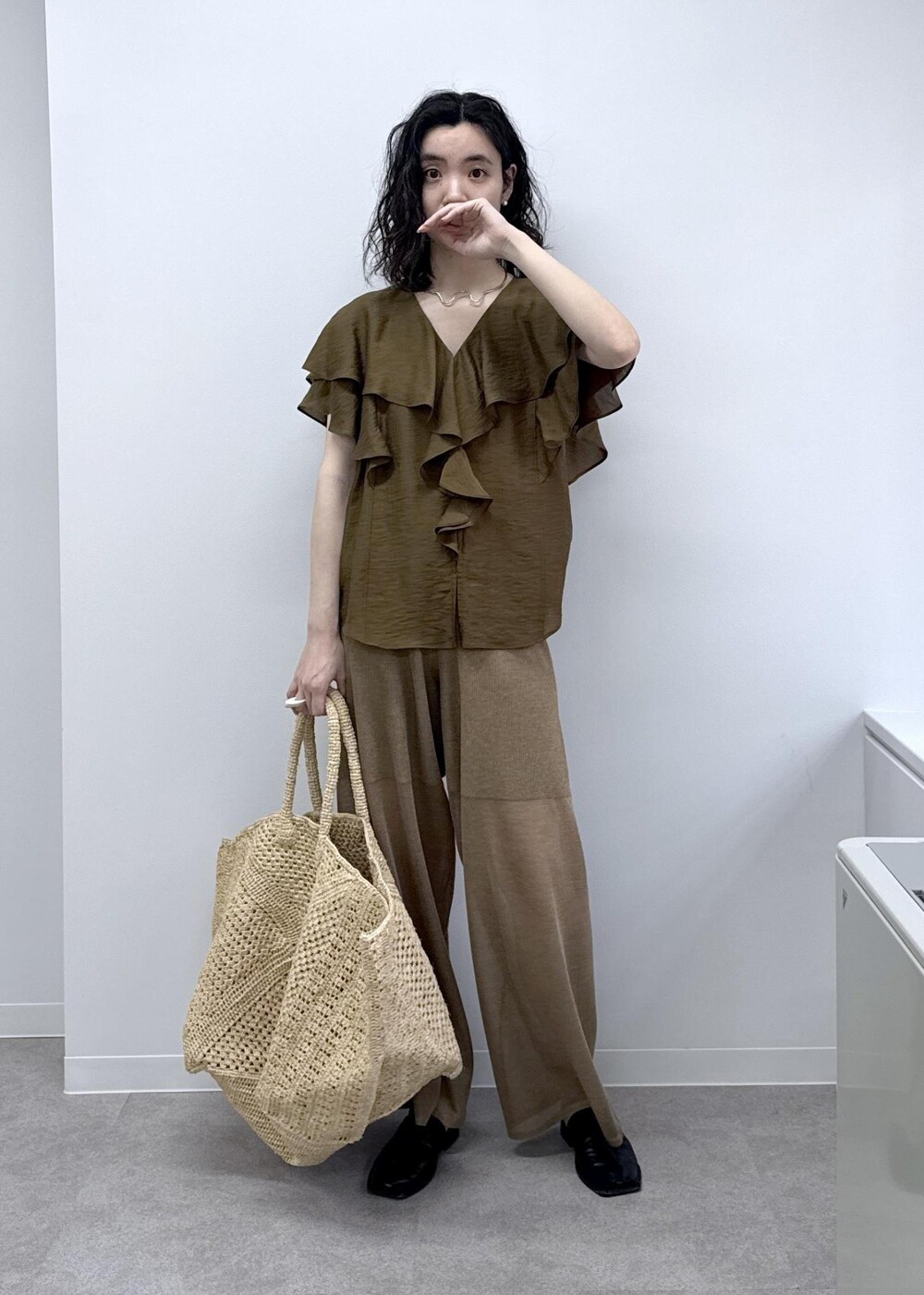 ホワイト系のかごバッグ、ブラウン系のシャツ/ブラウス、ゴールド系のその他パンツを着用したレディースの春コーディネートの2枚目の写真