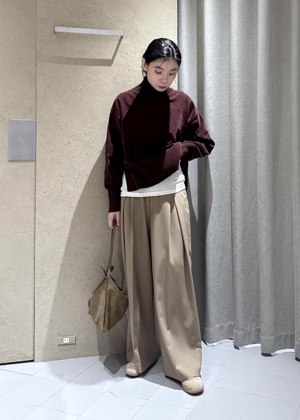 ホワイト系のTシャツ/カットソー、ベージュ系のスラックス、ブラウン系のショルダーバッグを着用したレディースの秋コーディネートの4枚目の写真