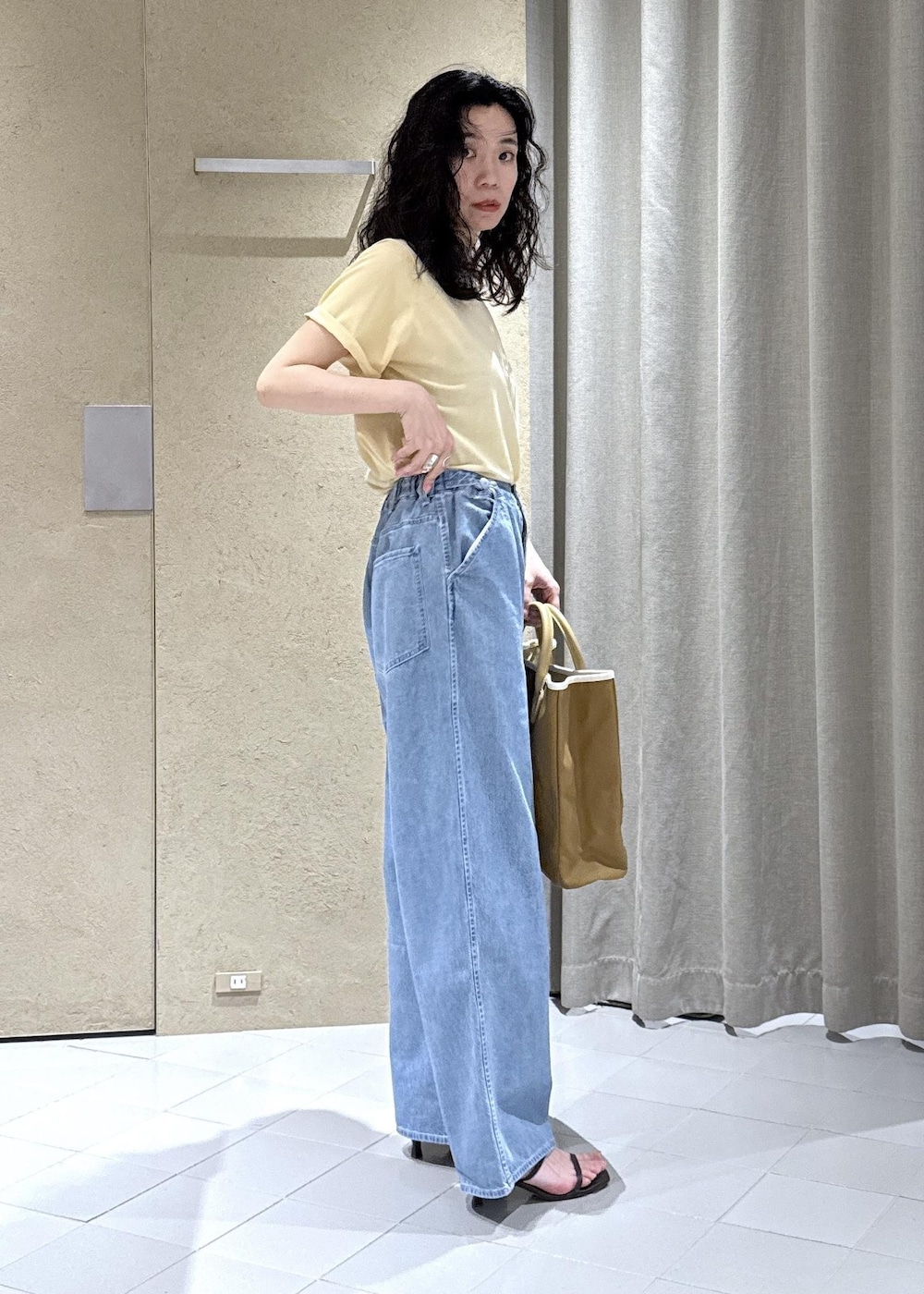 ホワイト系のTシャツ/カットソー、ブルー系のデニムパンツ、ベージュ系のトートバッグを着用したレディースの夏コーディネートの3枚目の写真