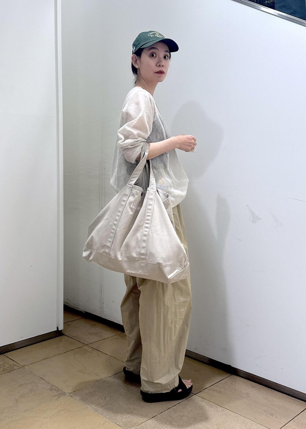 ベージュ系のその他パンツ、ホワイト系のニット/セーターを着用したレディースの夏コーディネートの2枚目の写真