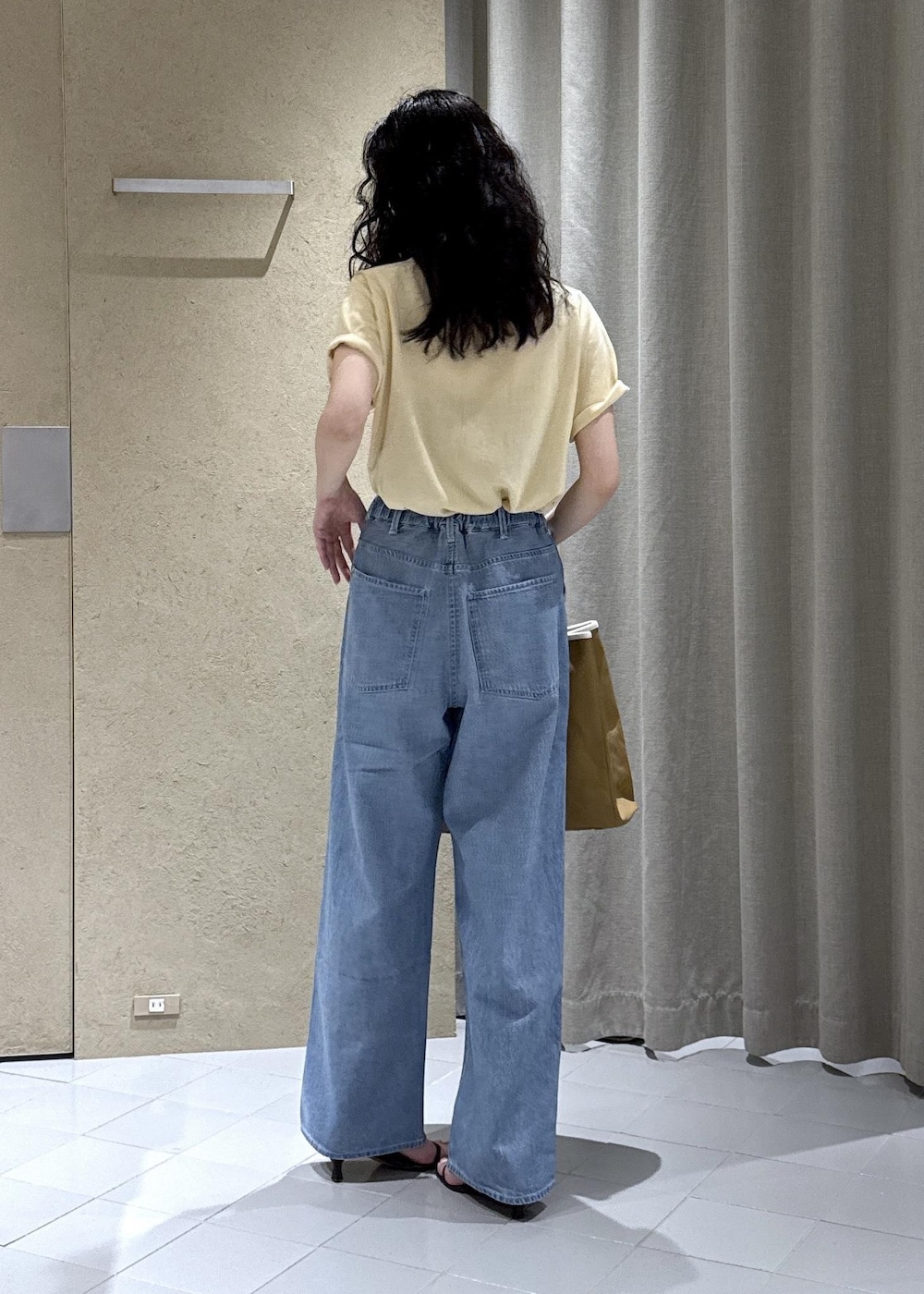 ホワイト系のTシャツ/カットソー、ブルー系のデニムパンツ、ベージュ系のトートバッグを着用したレディースの夏コーディネートの4枚目の写真