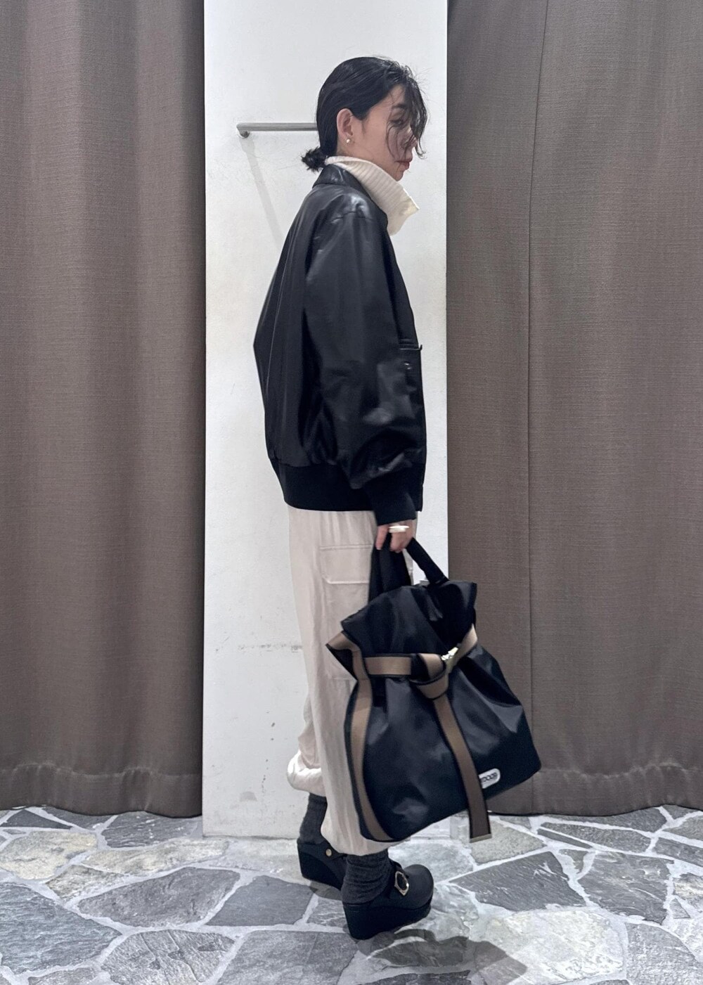 ホワイト系のカーゴパンツ、ブラック系のブルゾン、ホワイト系のカーディガン/ボレロを着用したレディースの冬コーディネートの8枚目の写真